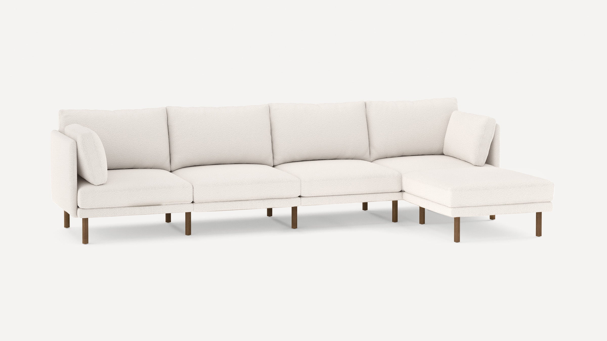Modern white sectional sofa with plush cushions and wooden legs, featuring a right chaise lounge and two accent pillows.