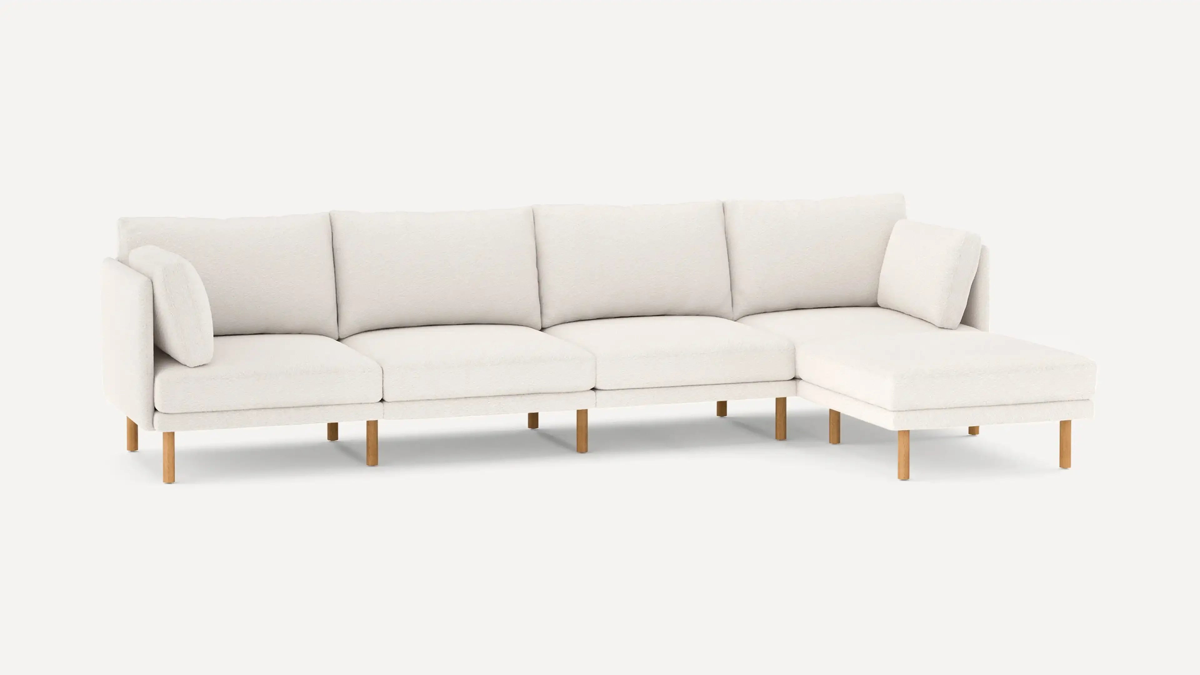 modern l - shaped sectional sofa with light beige upholstery, featuring wooden legs and clean, minimalist design