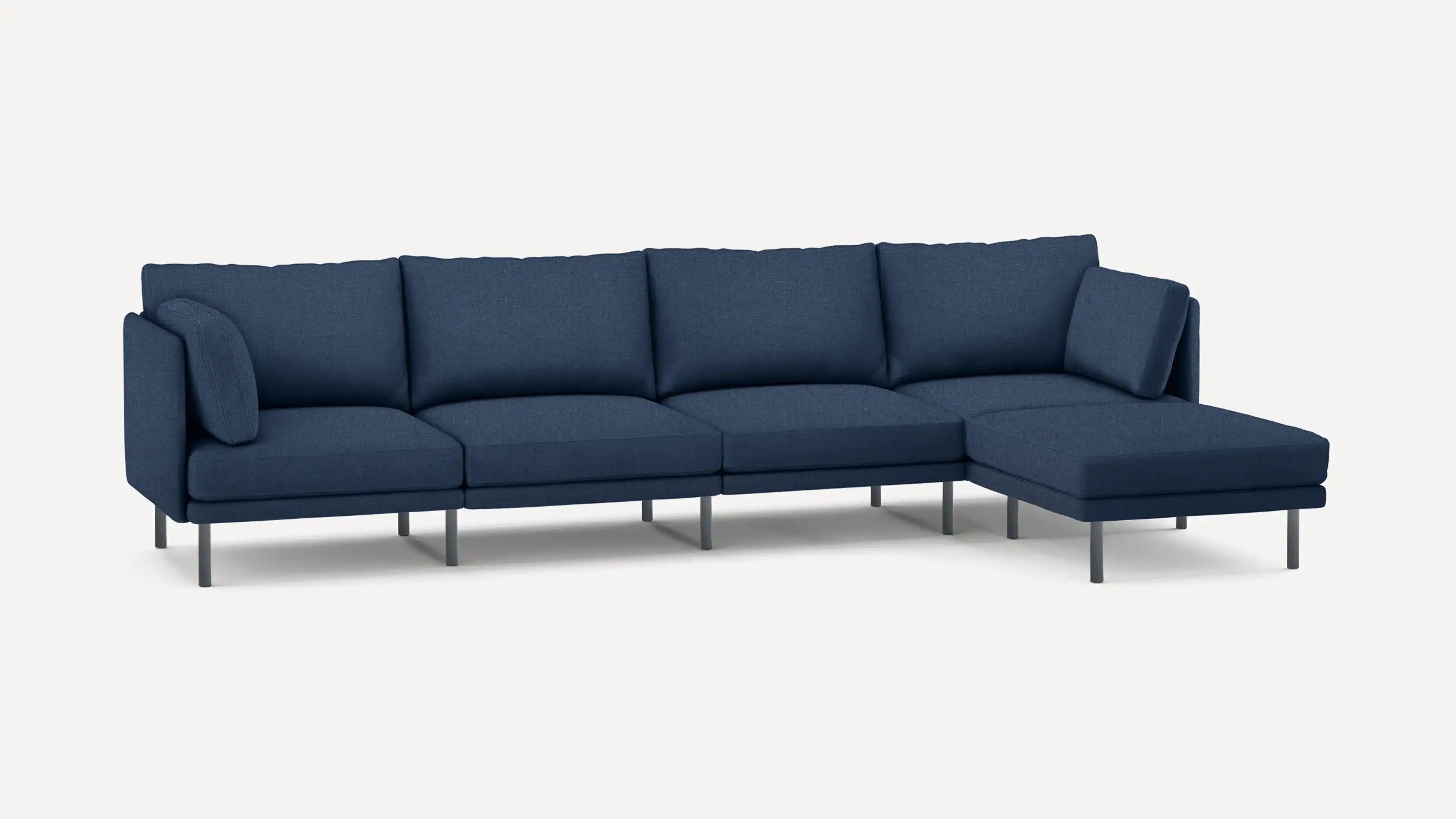 modern navy blue fabric sectional sofa with chaise lounge and matching ottoman, featuring sleek metal legs, on a white background