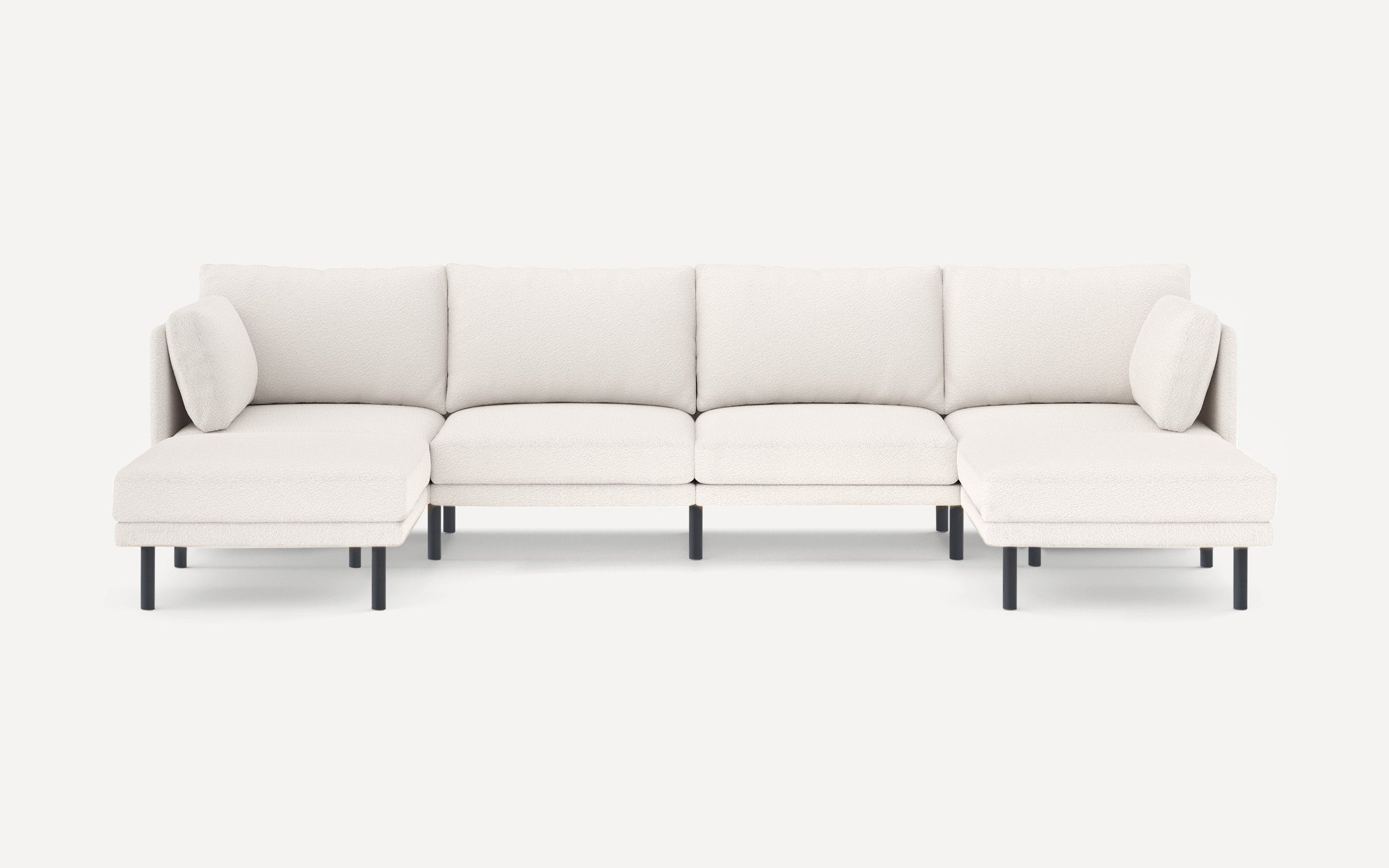Modern white sectional sofa with plush cushions, black legs, and a cozy, textured fabric upholstery.