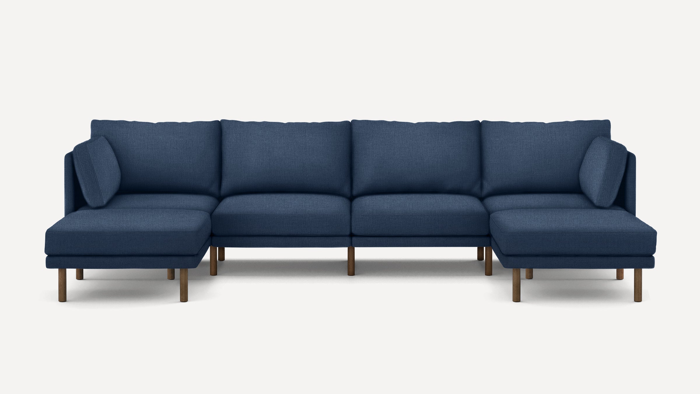 Large modern L-shaped sectional sofa with navy blue fabric upholstery and wooden legs on each section.