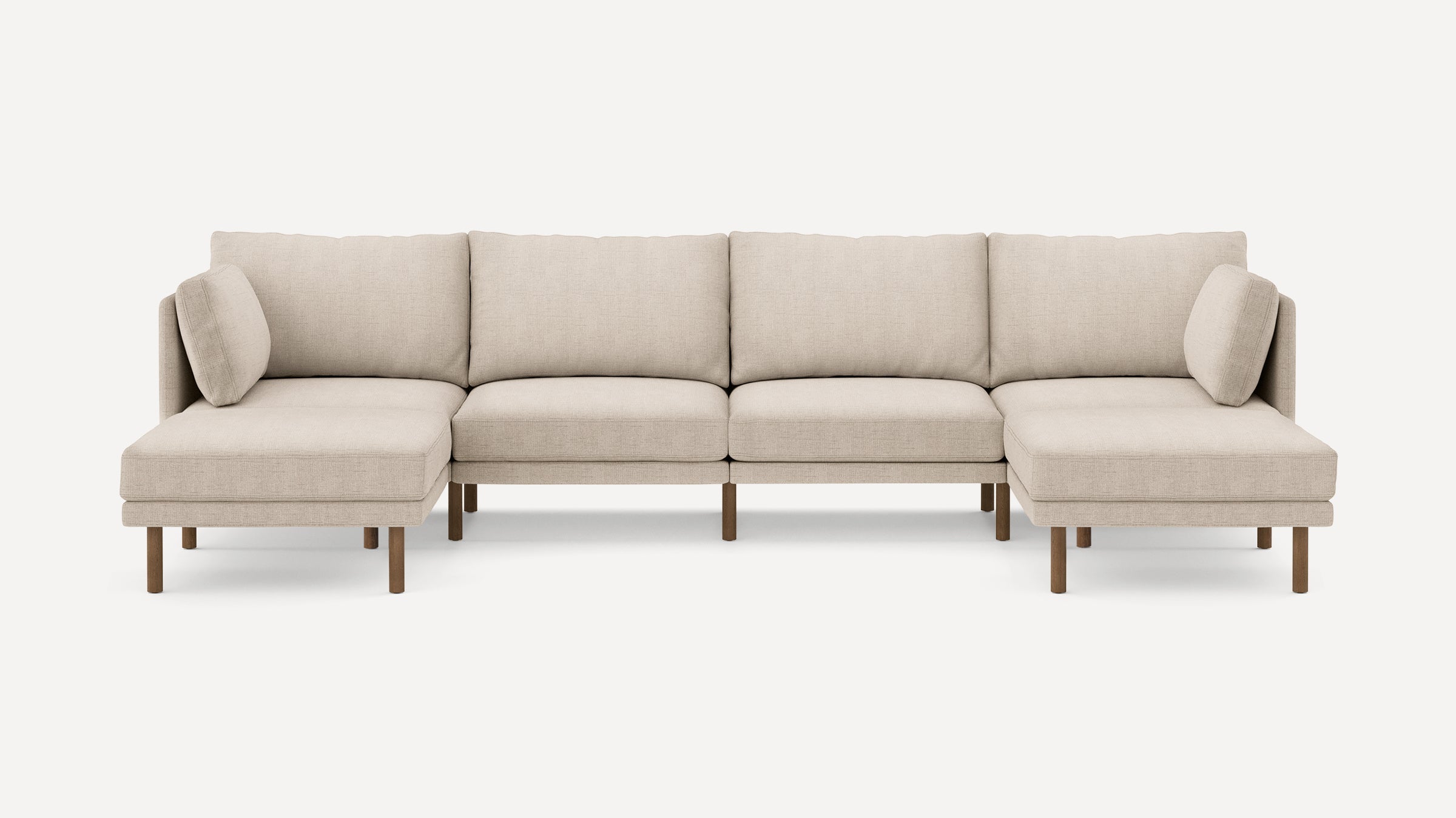 Beige fabric sectional sofa with wooden legs, featuring two chaise lounges and supportive back cushions.