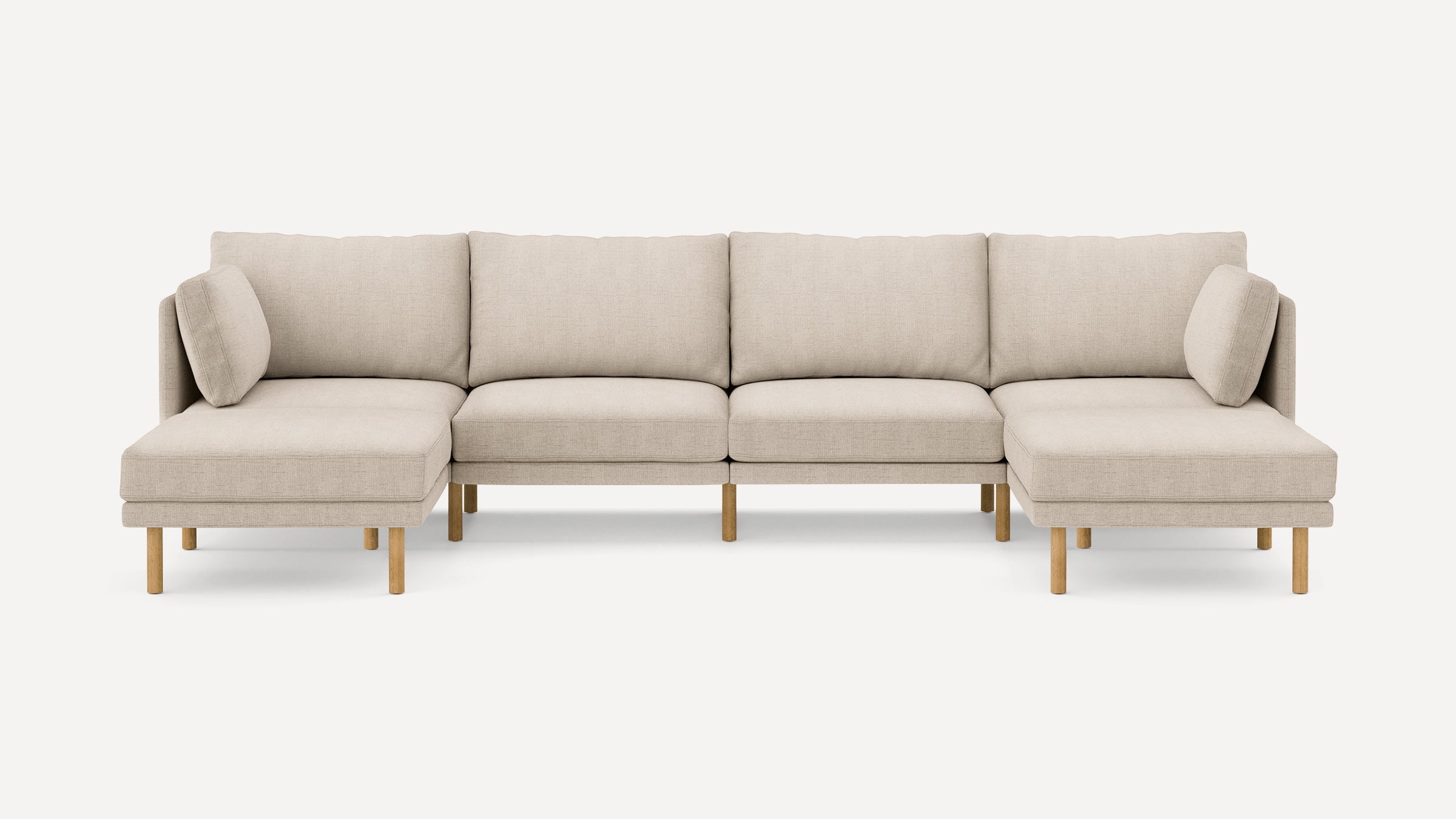 Beige linen sectional sofa with wooden legs, featuring chaise lounges on both ends and matching back cushions.
