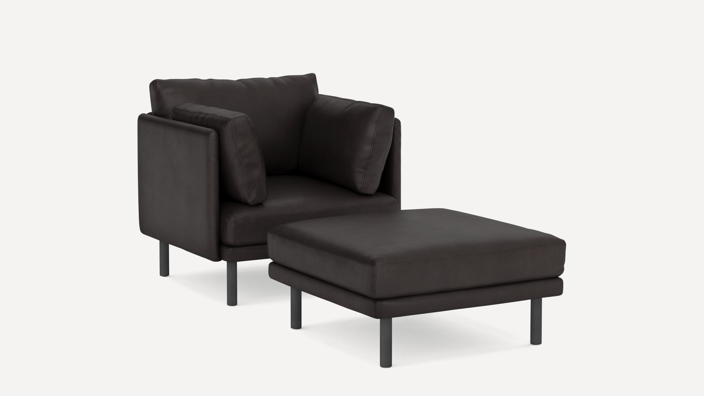 Modern black leather armchair with matching ottoman, featuring metal legs and plush cushions, on a plain white background.