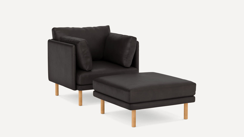 Modern dark brown leather armchair with matching cushioned ottoman, both featuring light wooden legs and clean, minimalist design.