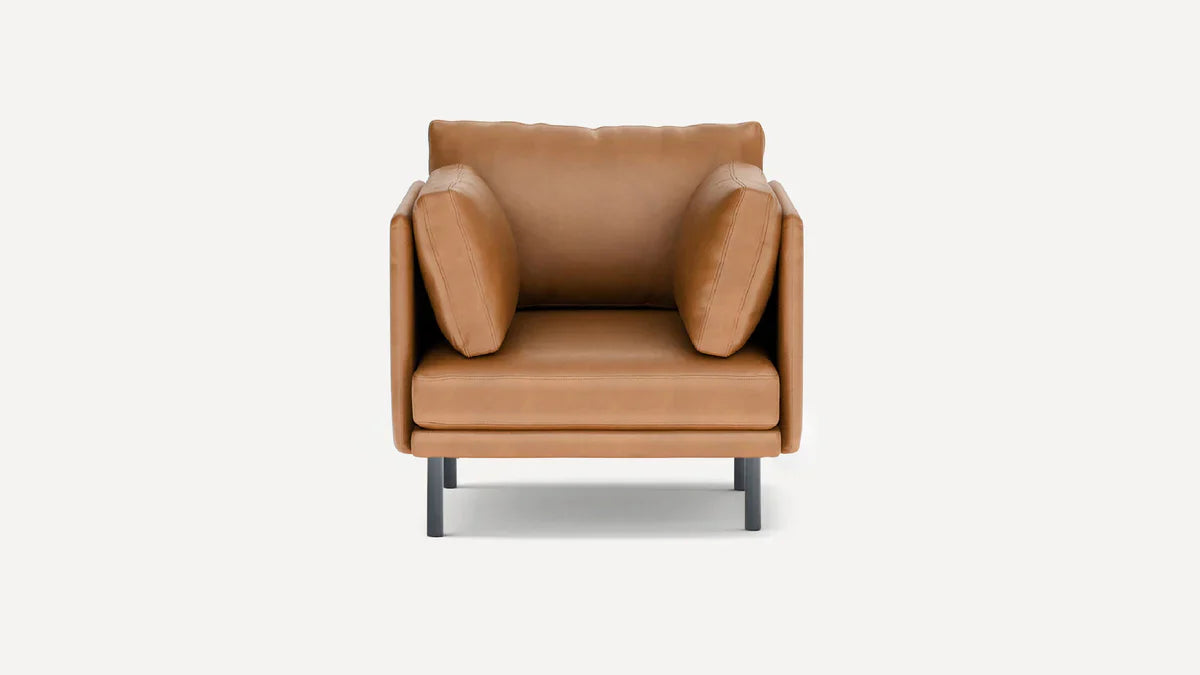 modern leather armchair with black metal legs and a tan cushion on a white background