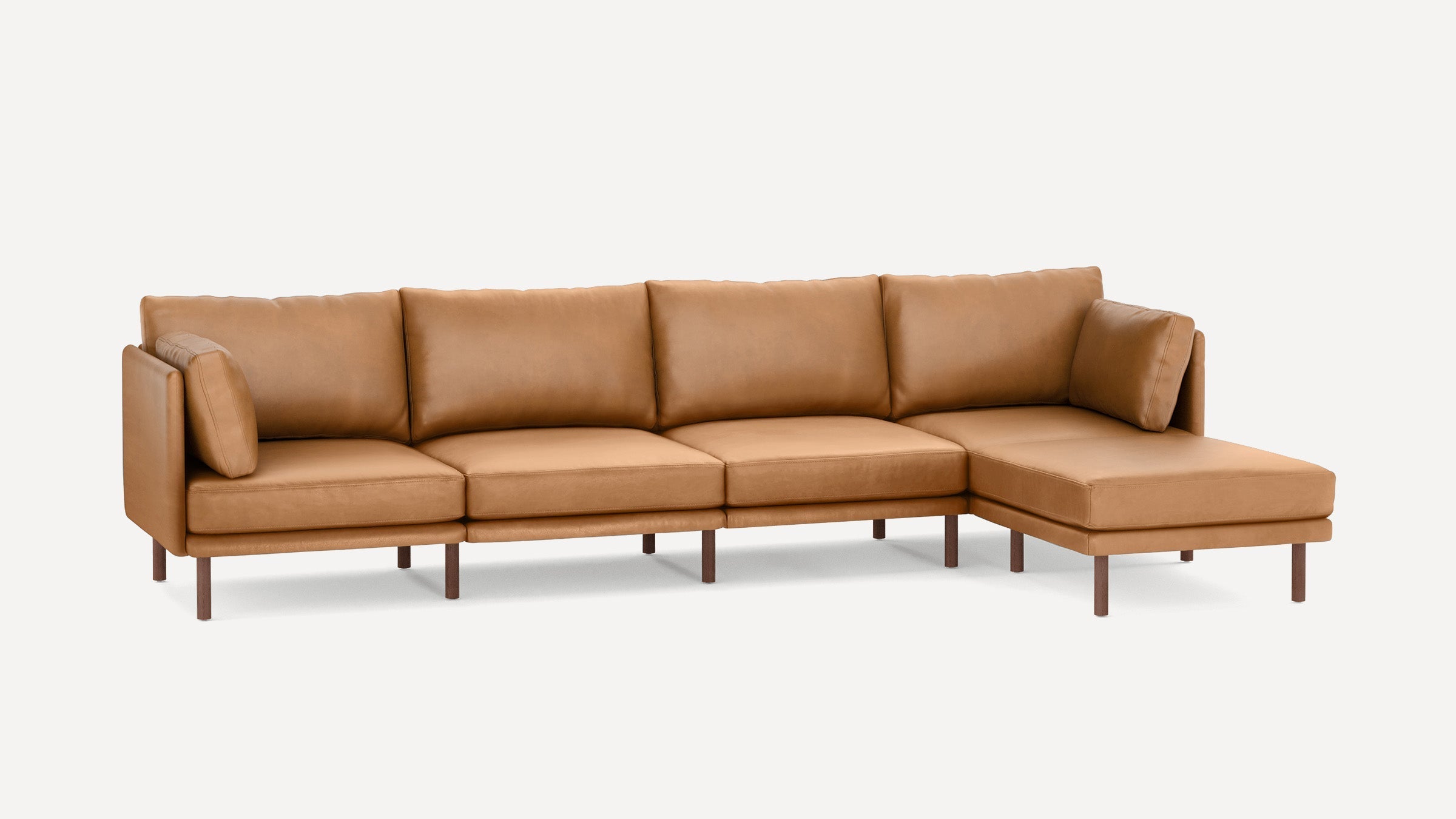 Modern L-shaped sectional sofa in tan leather with wooden legs and removable cushions, designed for spacious seating.