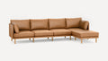Modern L-shaped sectional sofa with caramel brown leather upholstery and light wooden legs against a white background.