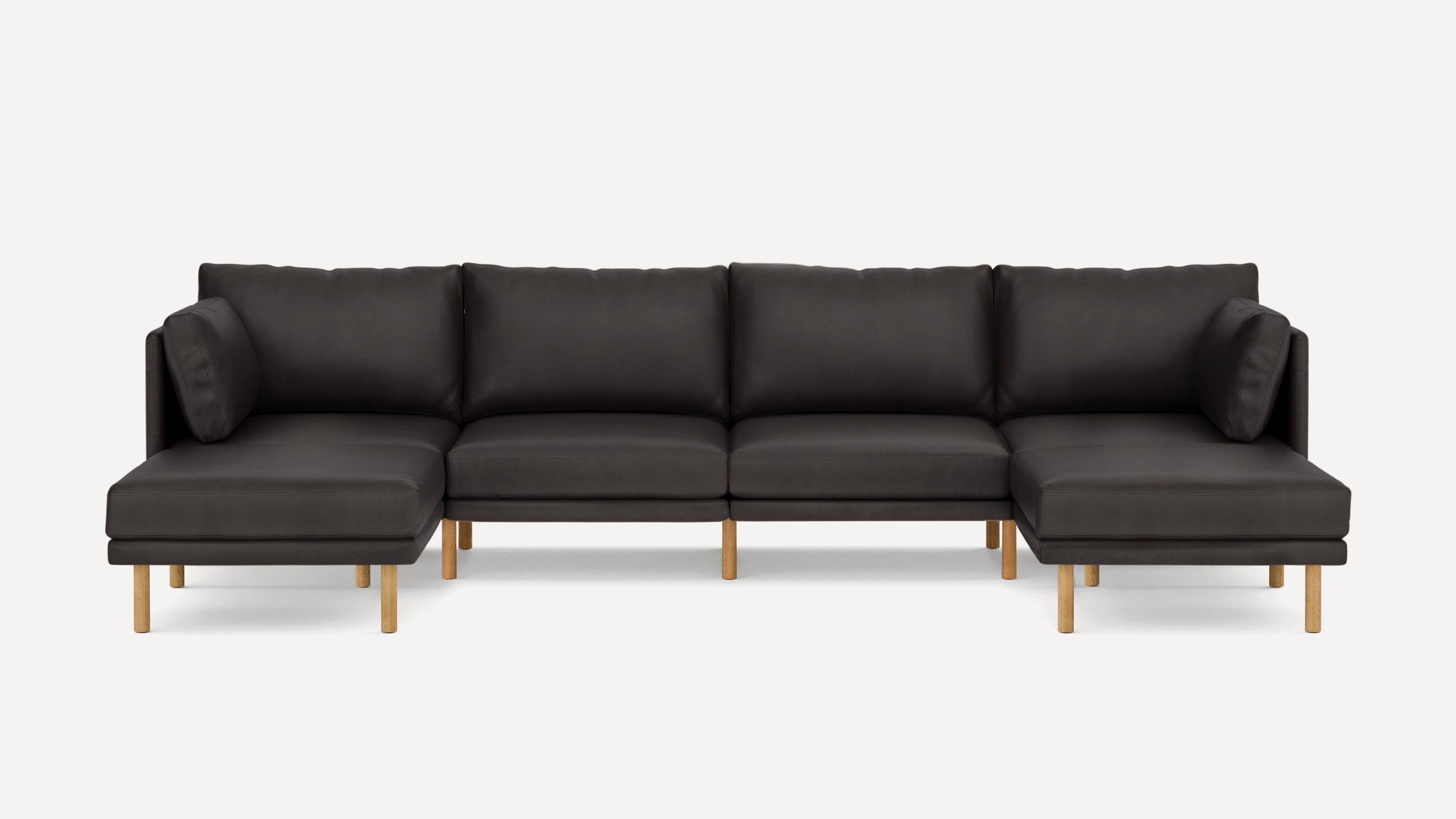 Modern dark brown leather sectional sofa with wooden legs, featuring two chaise ends and plush cushions on a plain white background.