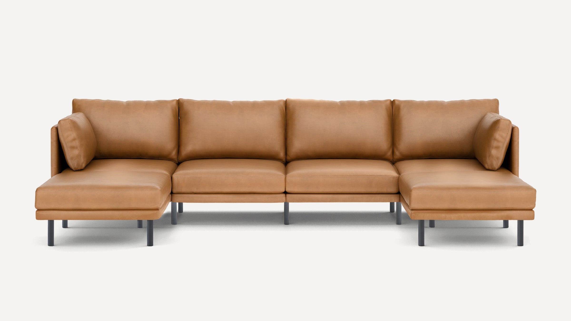 Modern tan leather sectional sofa with clean lines, low back cushions, and black metal legs on both ends.