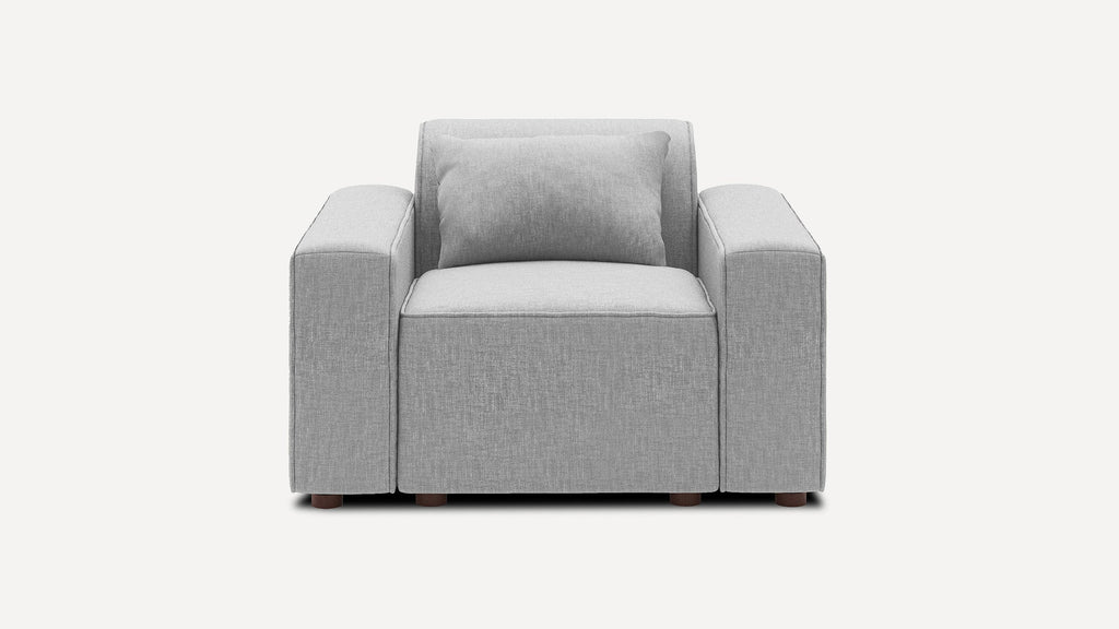 Modern grey fabric armchair with wide armrests and a matching rectangular cushion, shown against a plain white background.