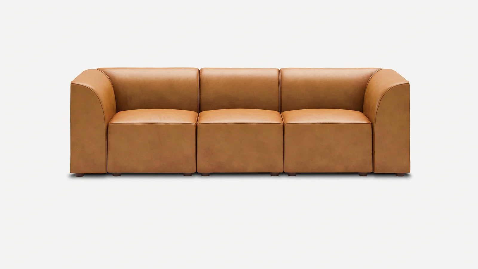 Three-seater modern sofa in light brown leather with wide armrests and boxy cushions, set against a plain white background.
