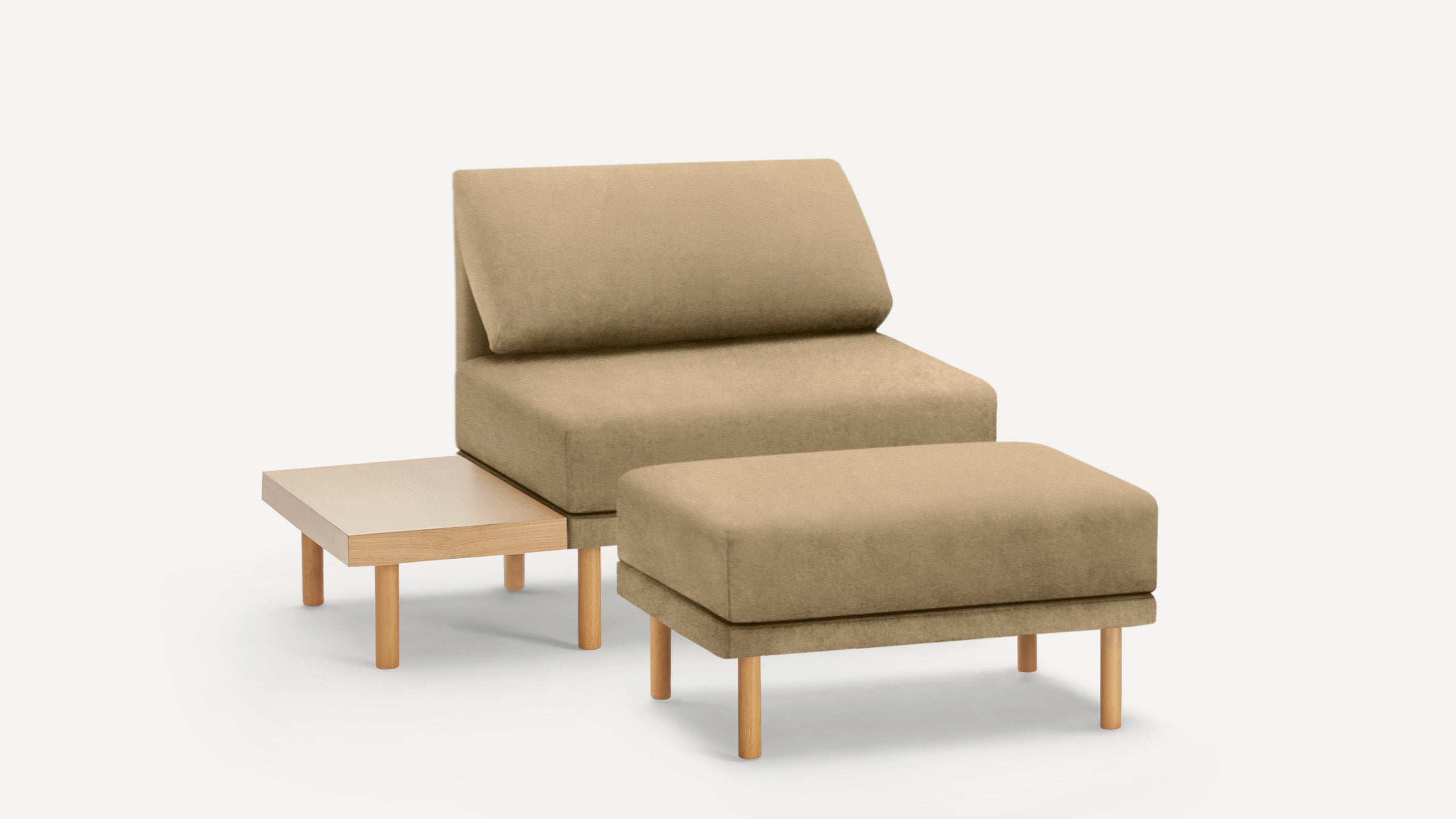 Beige cushioned lounge chair with matching ottoman and attached light wood side table, all with round wooden legs.