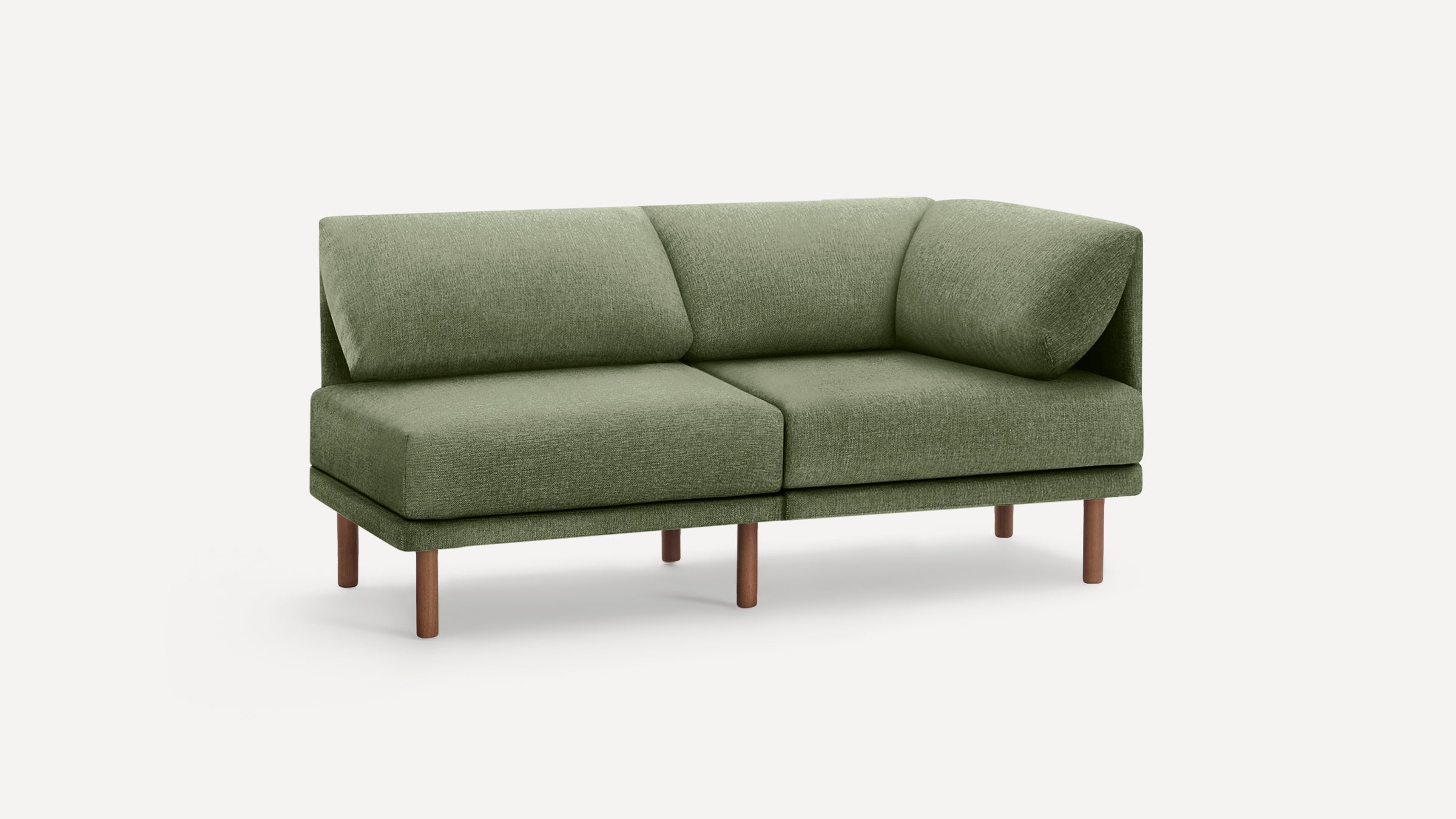 Modern olive green fabric corner sofa with plush cushions and slender wooden legs on white background.