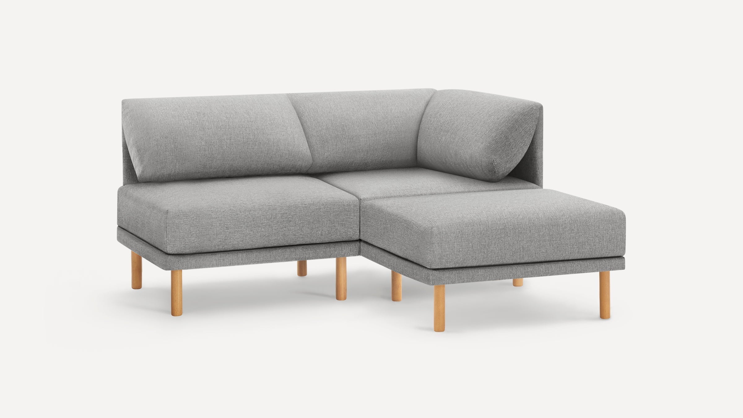 Modern gray fabric sectional sofa with wooden legs and corner backrest cushion on white background.