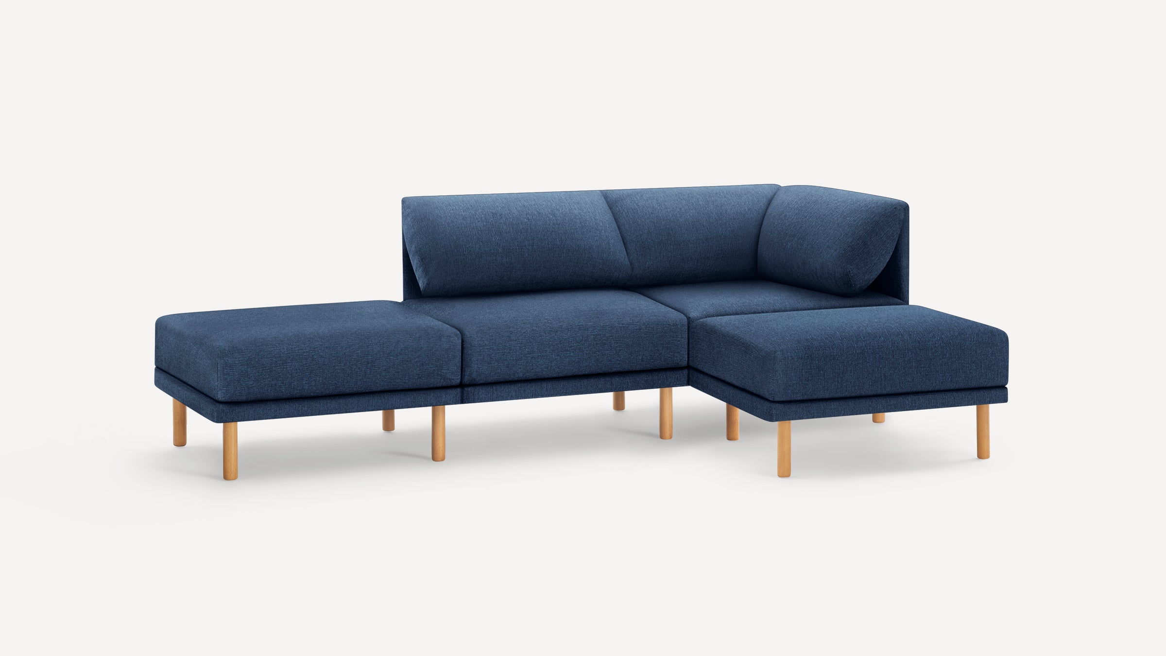 Modern sectional sofa upholstered in blue fabric with clean lines and wooden legs, featuring a chaise lounge on the right side.