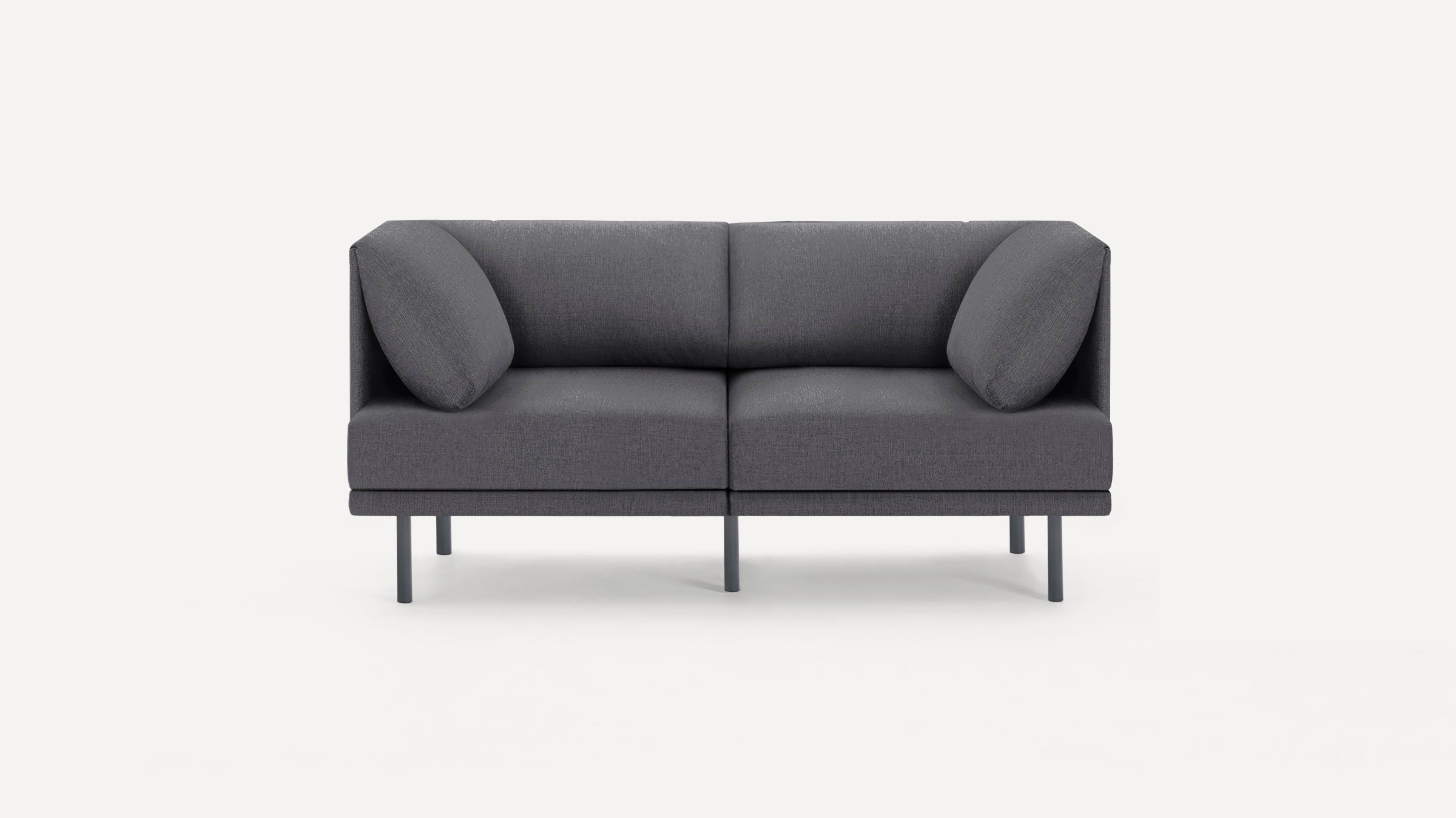 Modern dark gray fabric two-seater sofa with angled cushions and slim black metal legs on plain white background.
