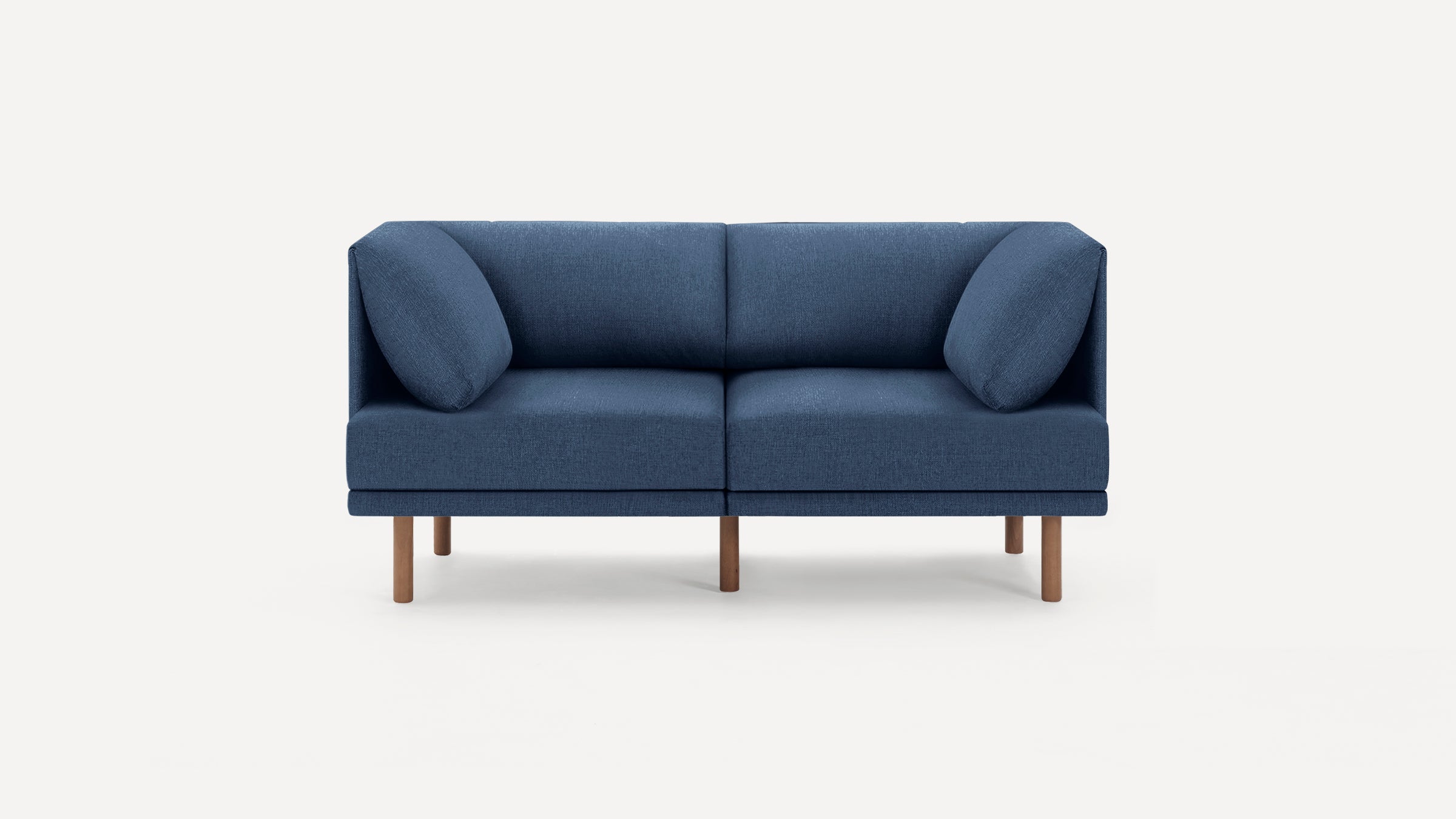 Modern two-seater sofa in dark blue fabric with clean lines, wooden legs, and two matching angled cushions.