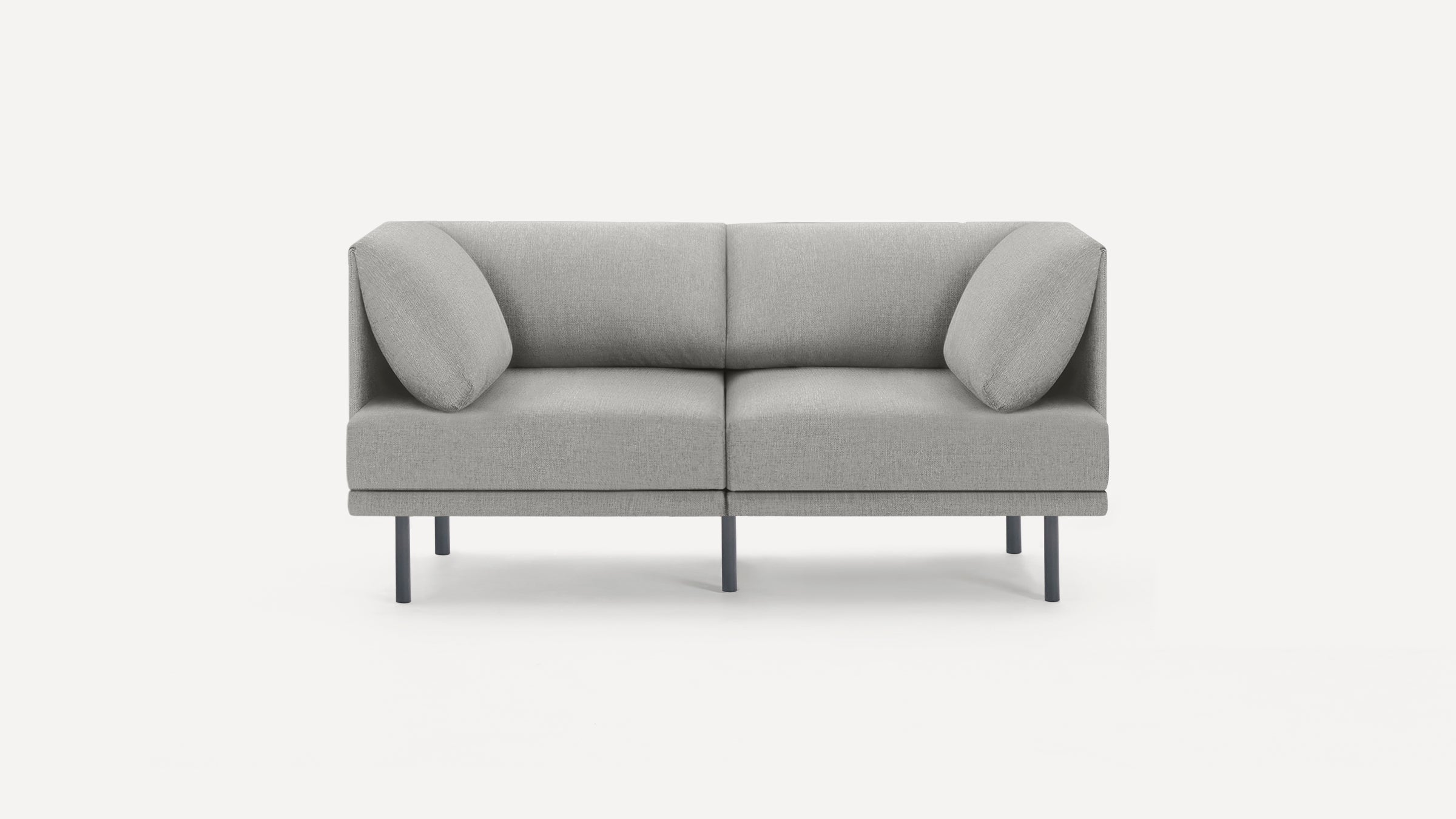Modern light gray fabric loveseat sofa with two matching round accent pillows and thin black metal legs on white background.