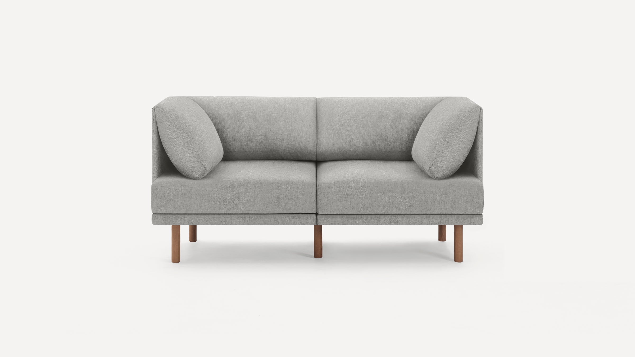 Modern gray fabric two-seater sofa with angled back cushions and wooden legs, set against a white background.