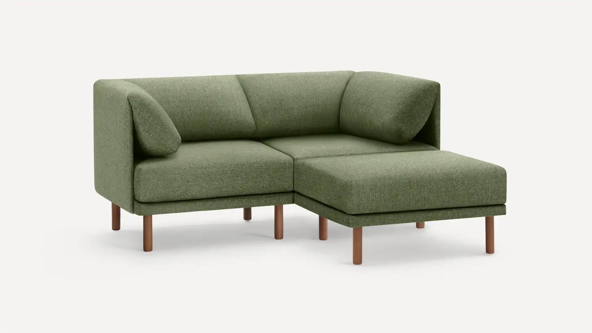 modern green fabric sectional sofa with wooden legs and matching cushions on a white background