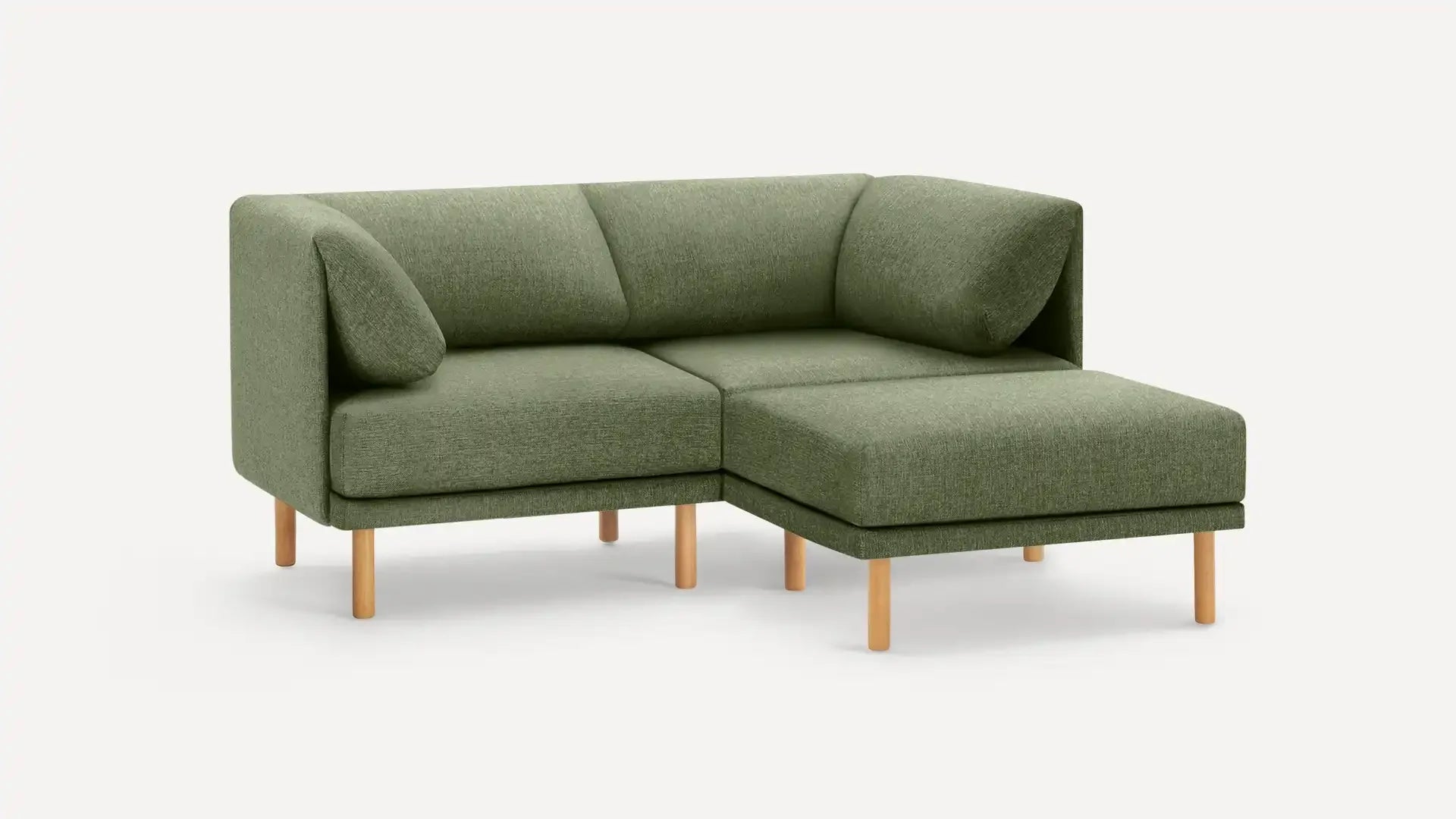 modern green fabric sectional sofa with wooden legs and matching cushions on a white background