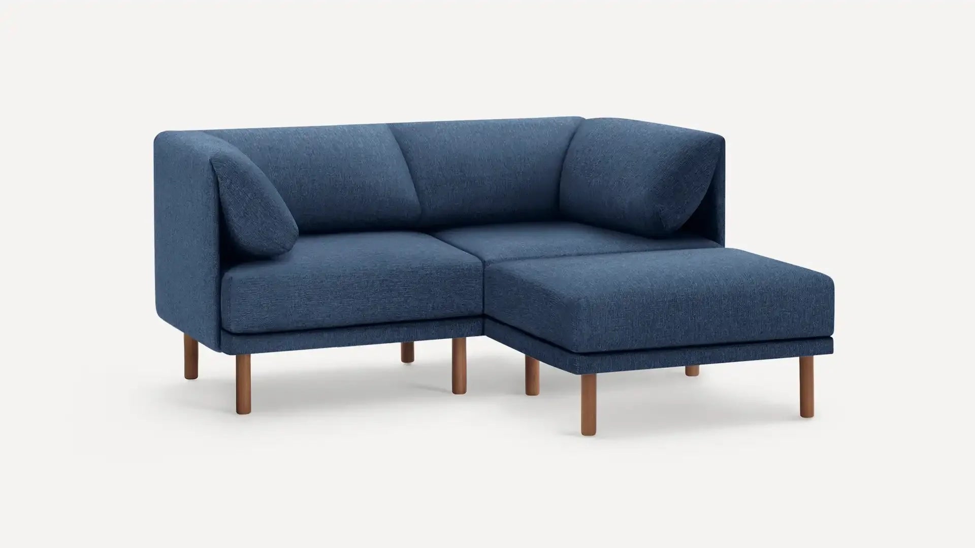 modern blue fabric sectional sofa with wooden legs and matching cushions, featuring a chaise lounge and matching ottoman