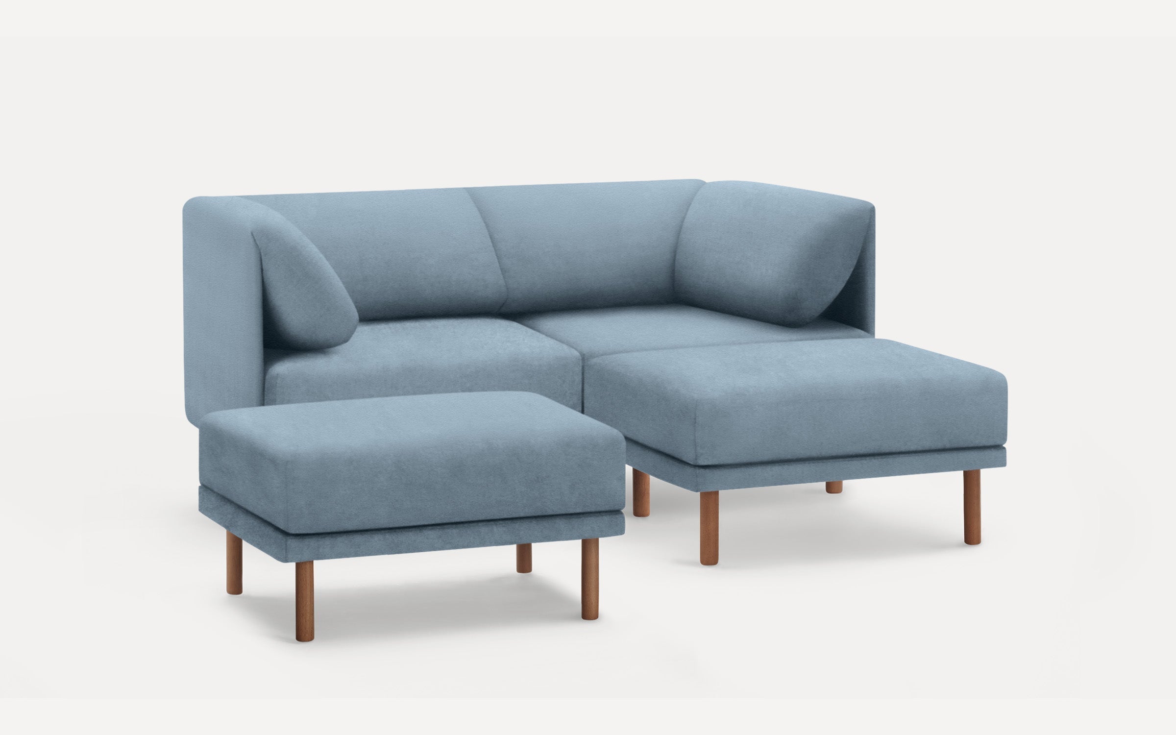 Modern light blue sectional sofa with matching ottoman, wooden legs, clean lines, and plush cushions.