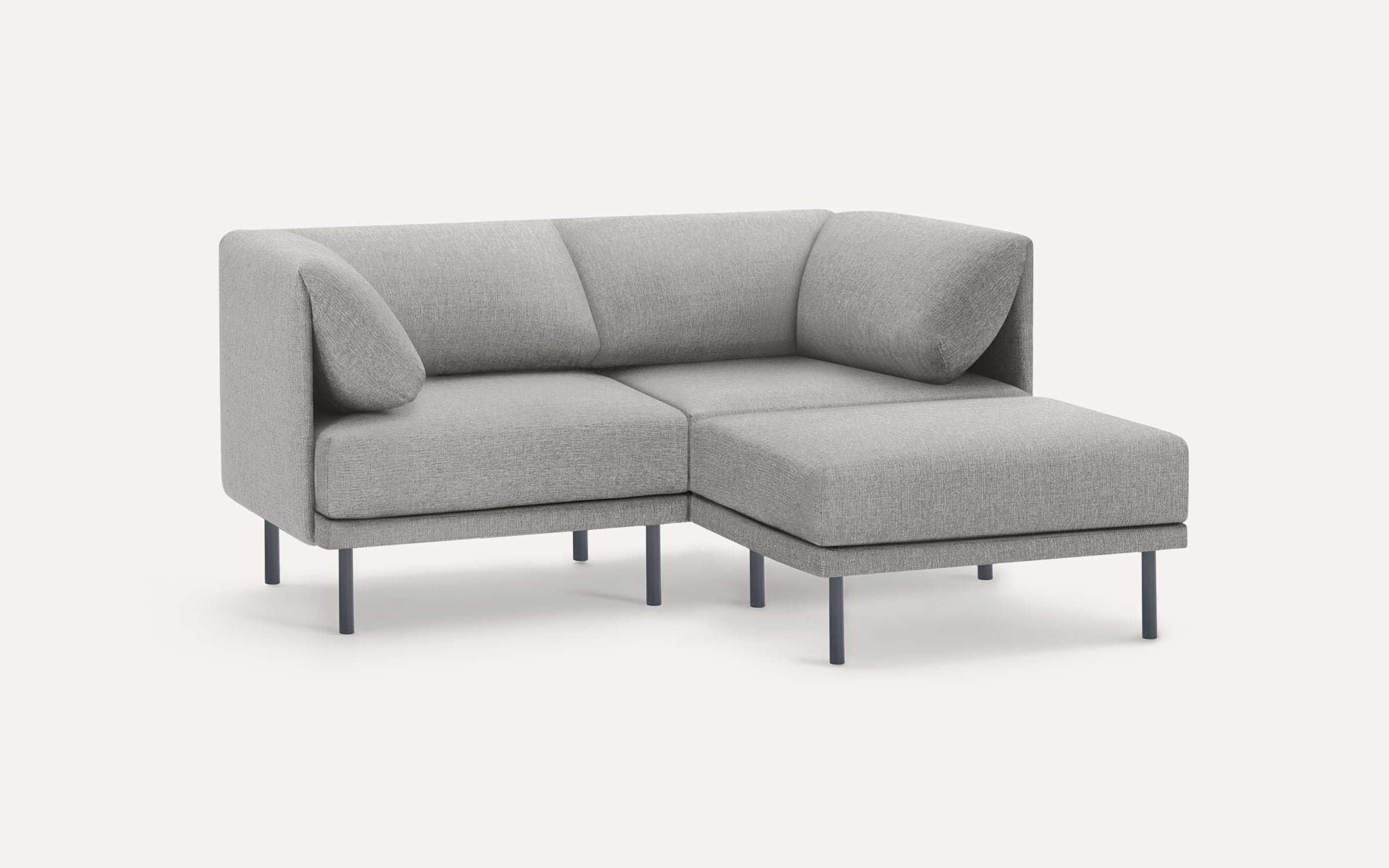 Modern light gray sectional sofa with left armrest, right chaise, cushioned back, metal legs, and two angled pillows.