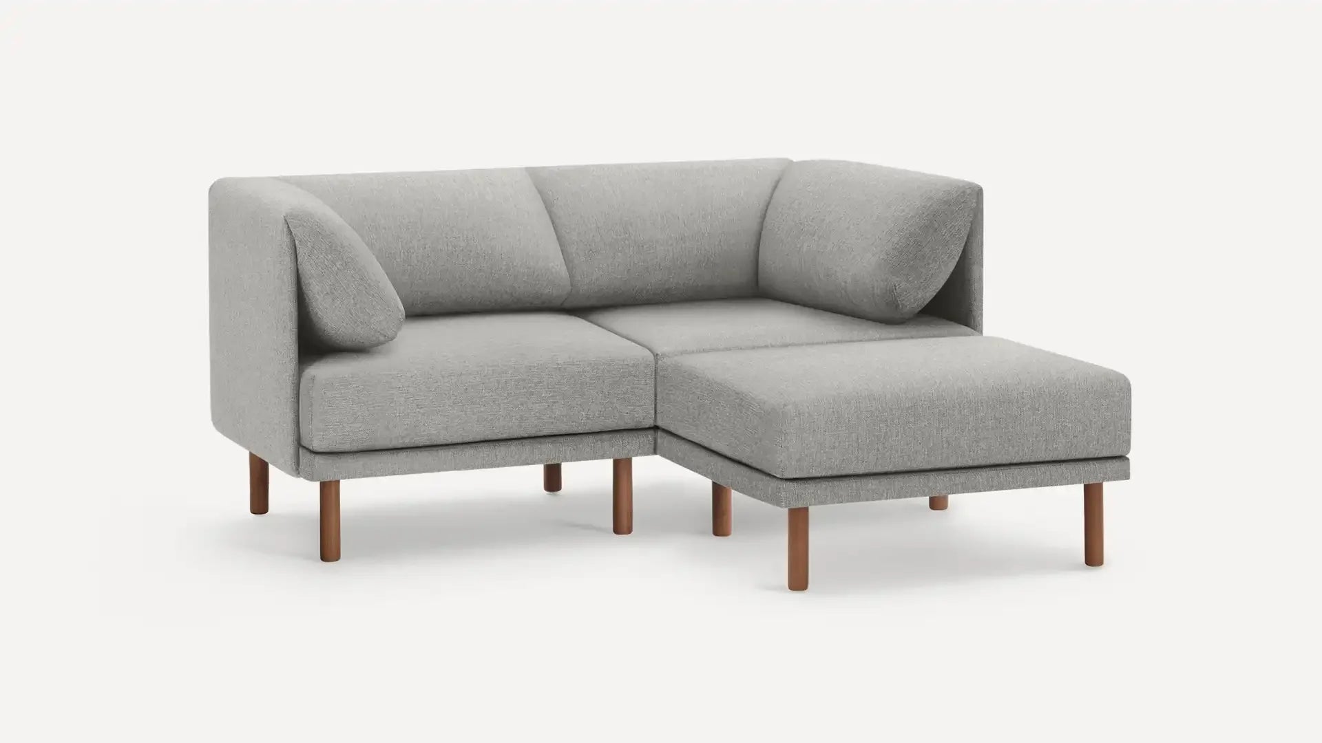 modern light gray fabric sectional sofa with wooden legs and matching ottoman, featuring a clean, minimalist design