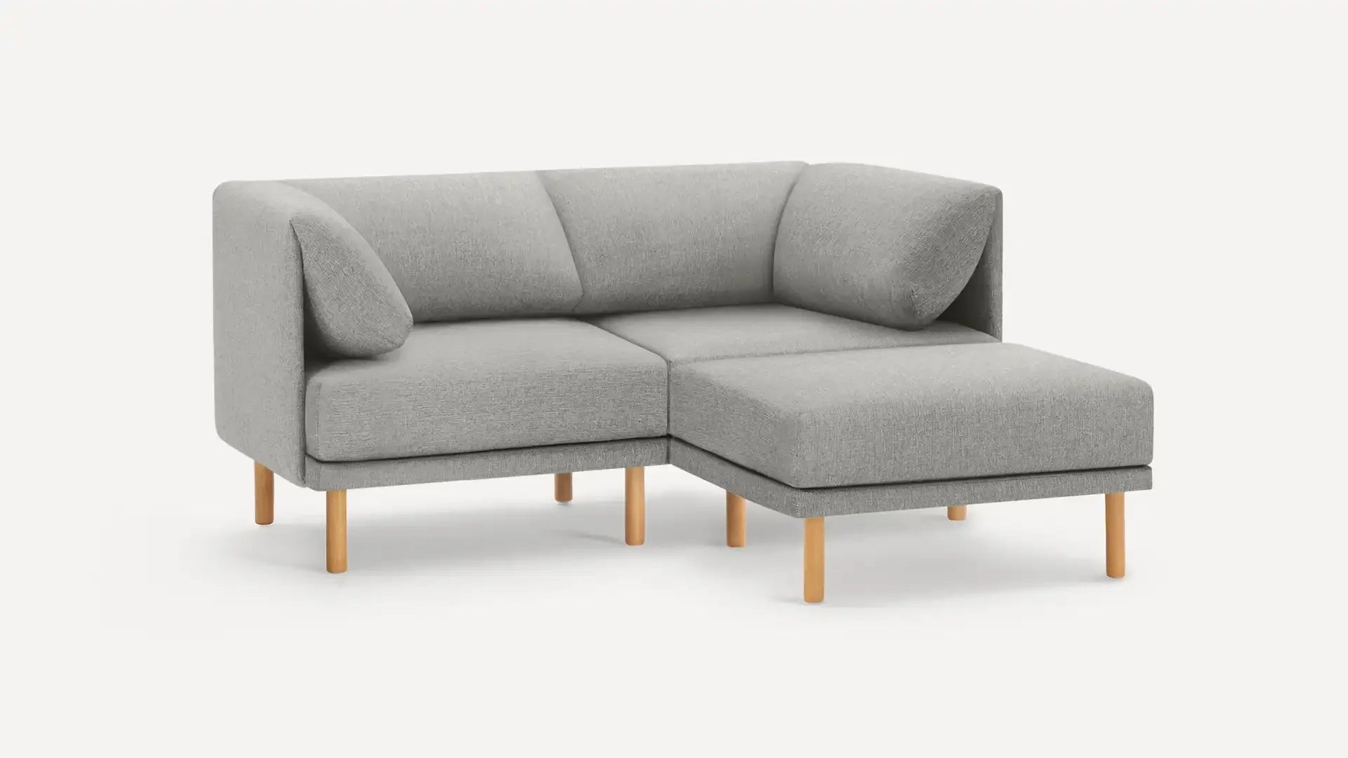 modern light gray fabric sectional sofa with wooden legs and matching ottoman, featuring a clean, minimalist design