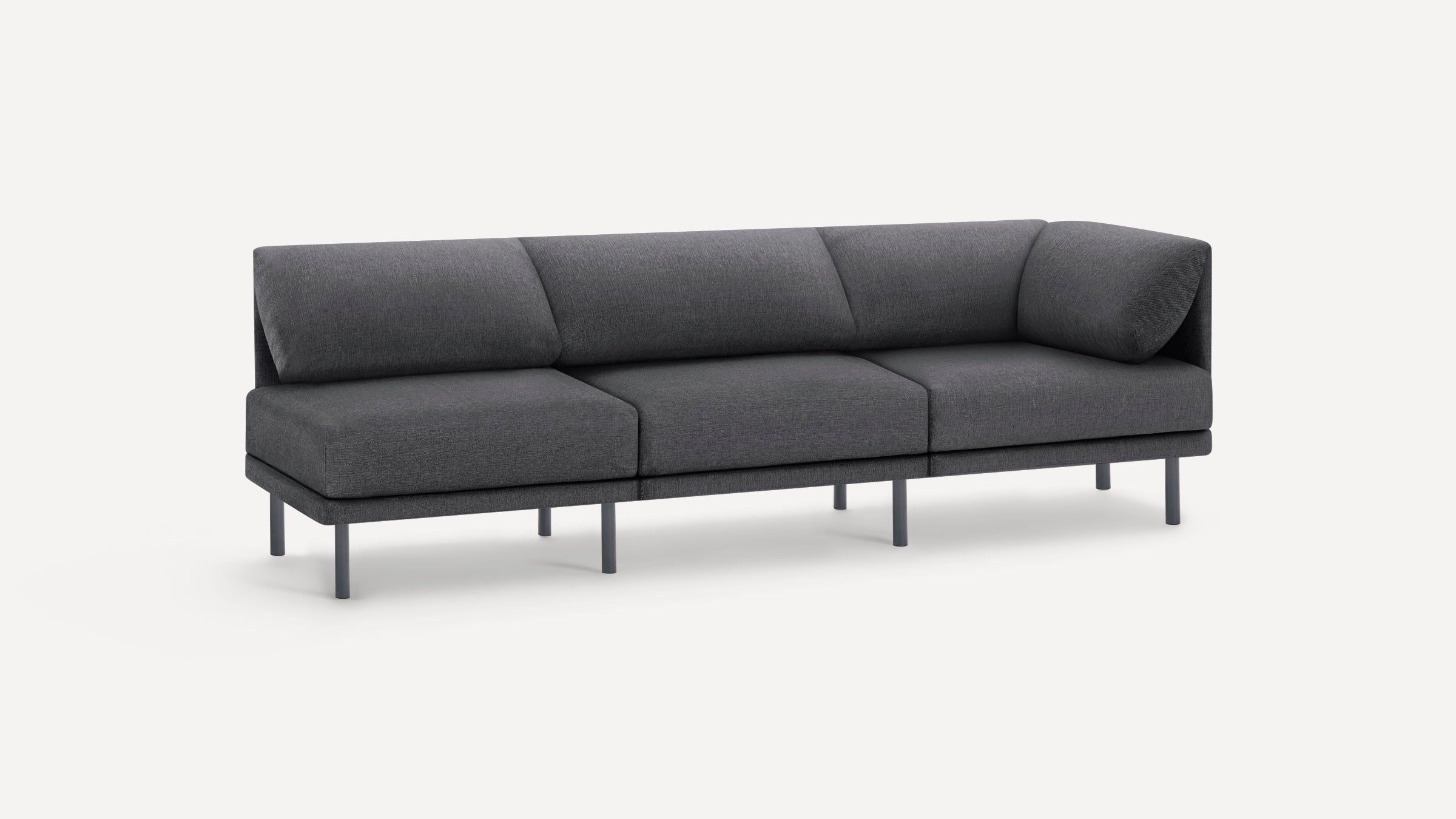 Modern dark gray three-seater sofa with angled backrest cushions and slim, round black legs on a white background.