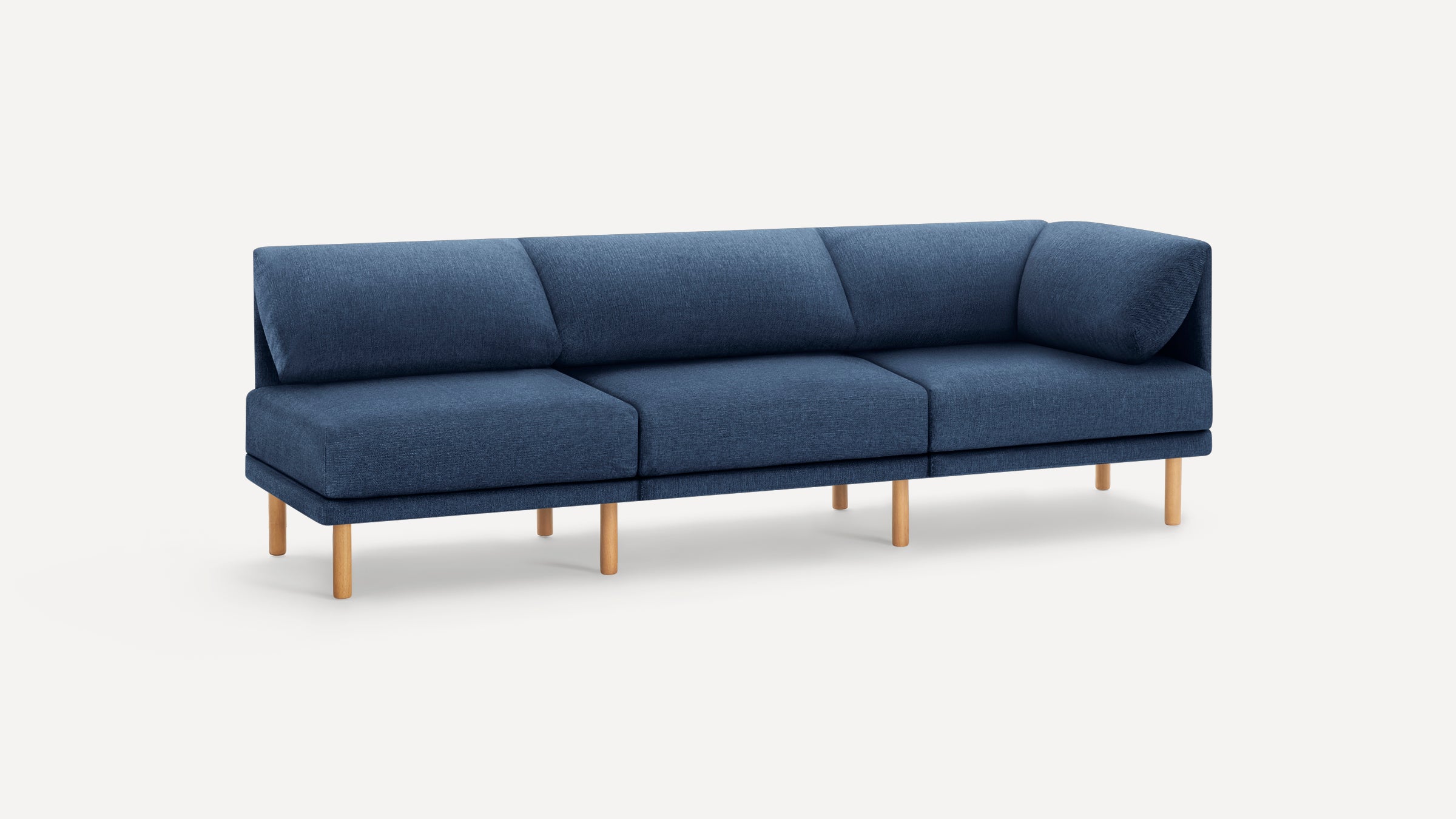 Modern navy blue upholstered sectional sofa with light wooden legs and angled back cushions, set against a plain white background.