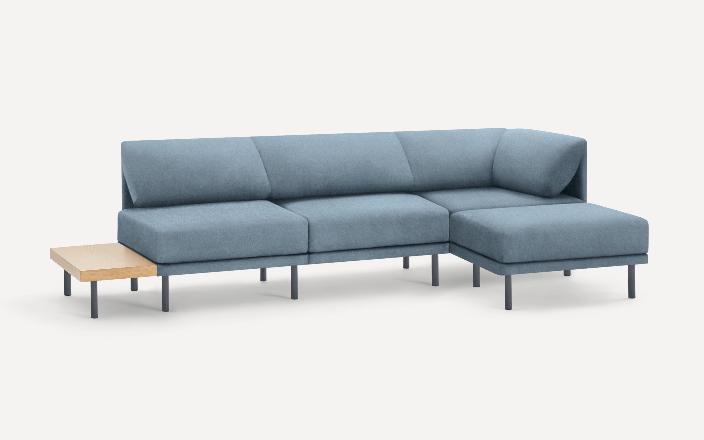 modern blue sectional sofa with chaise lounge and wooden side table on white background