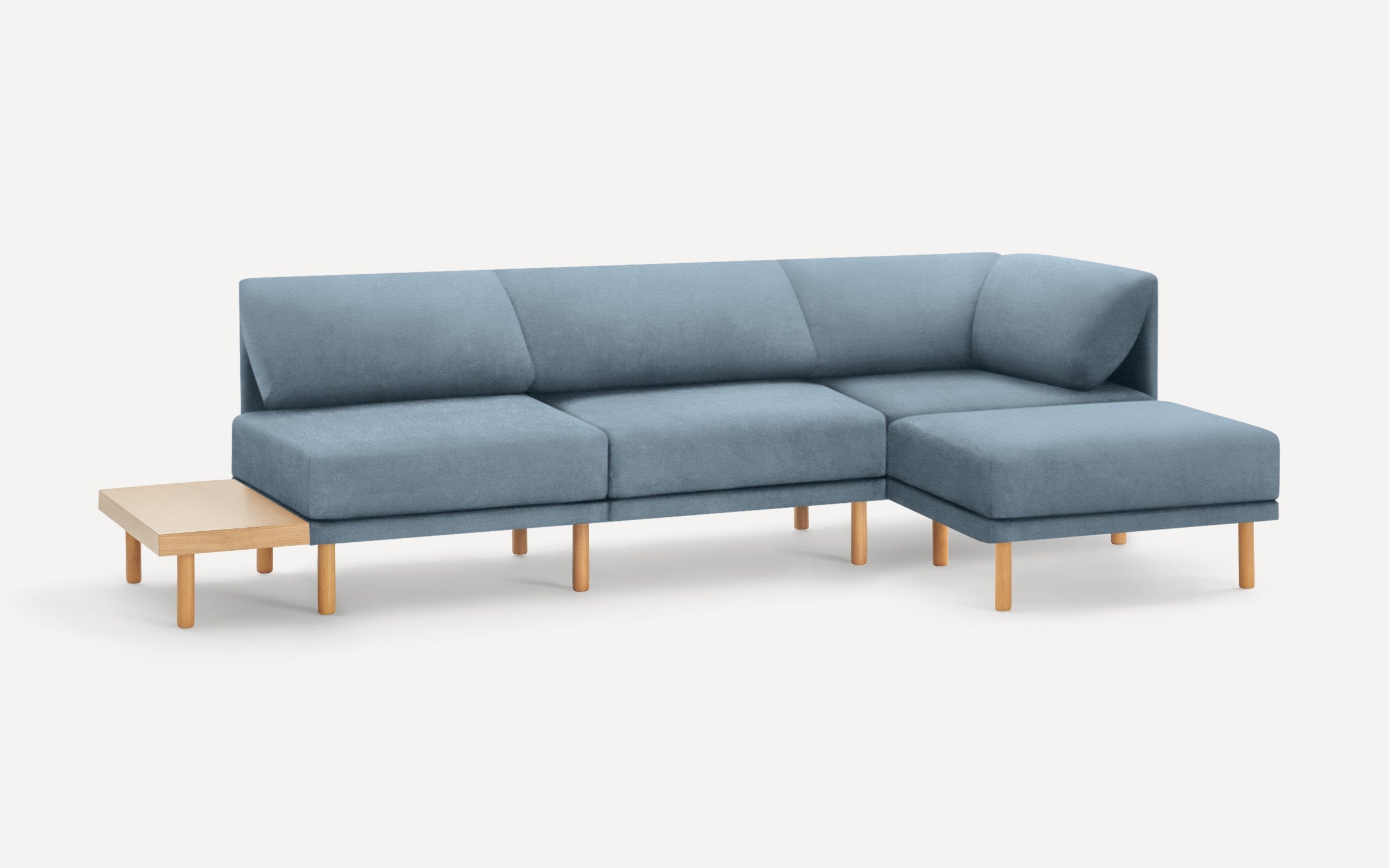 modern light blue sectional sofa with wooden legs and matching ottoman, featuring a clean, minimal design