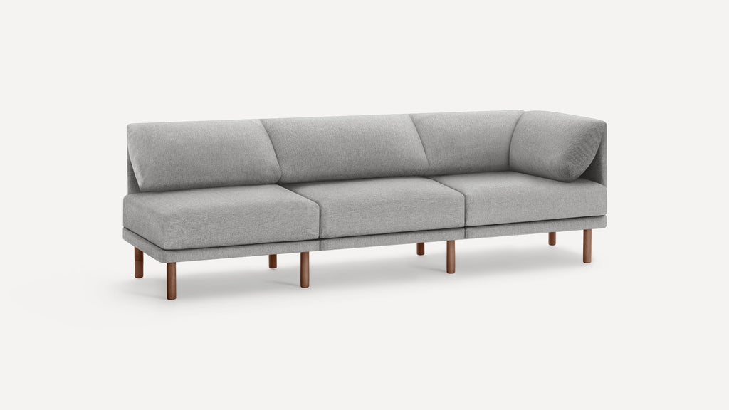Modern light gray fabric sectional sofa with wooden legs and angled back cushions on a plain white background.