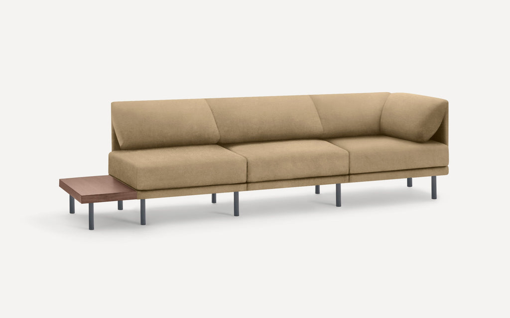 modern beige fabric sectional sofa with black metal legs and a wooden side table on a white background