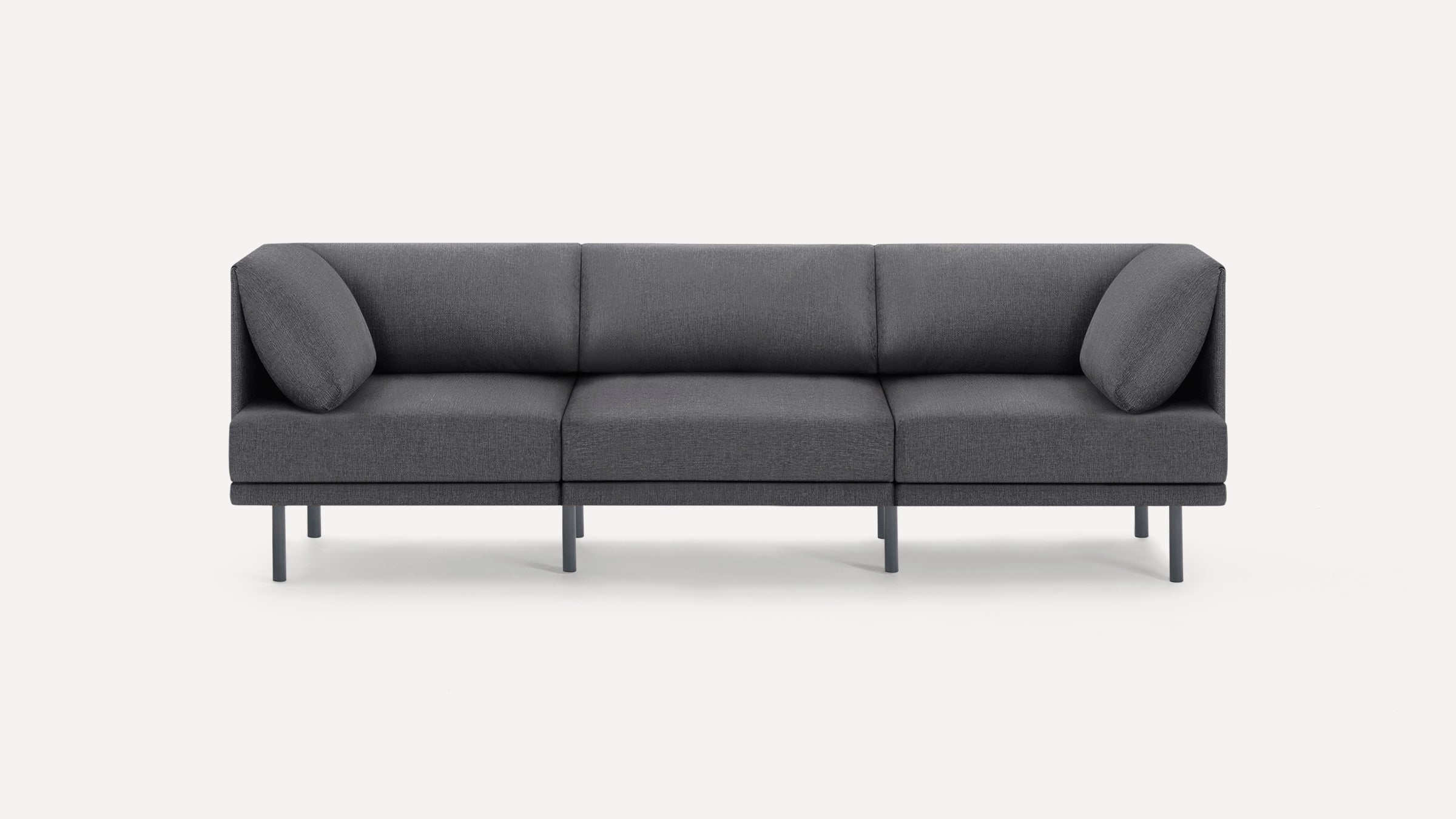 Modern three-seater gray fabric sofa with clean lines, metal legs, and two angled side cushions on a white background.
