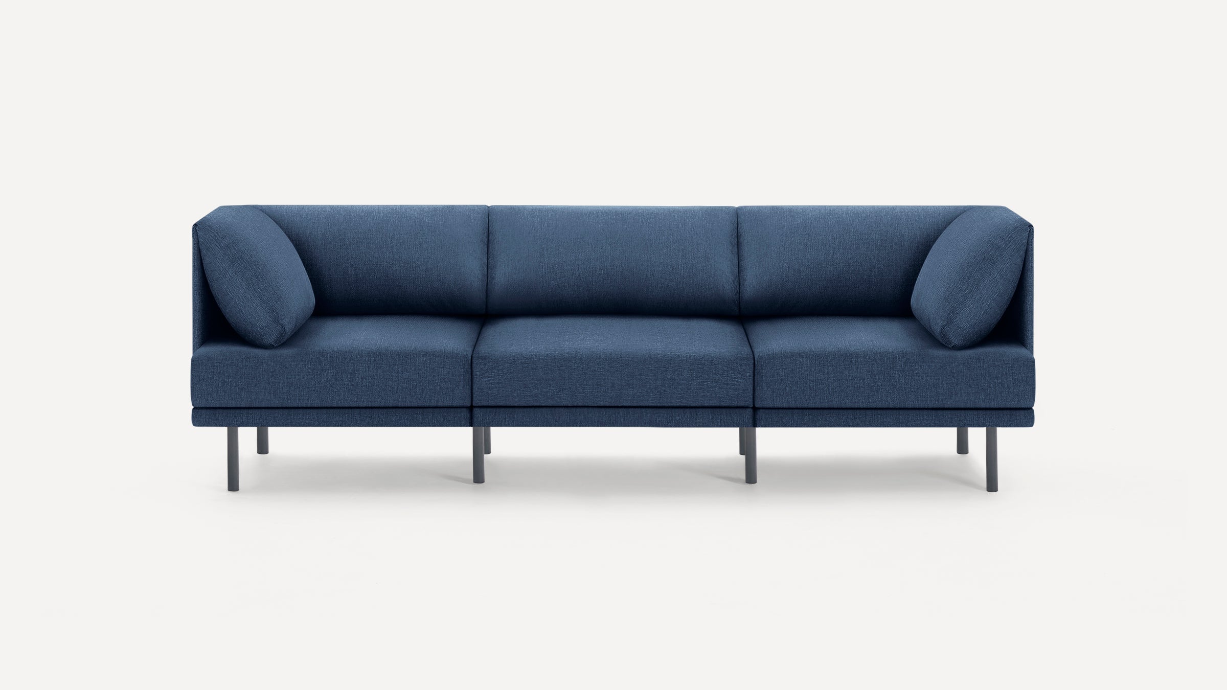 Modern three-seater sofa with deep blue fabric upholstery, minimalist design, and slim black metal legs on a white background.