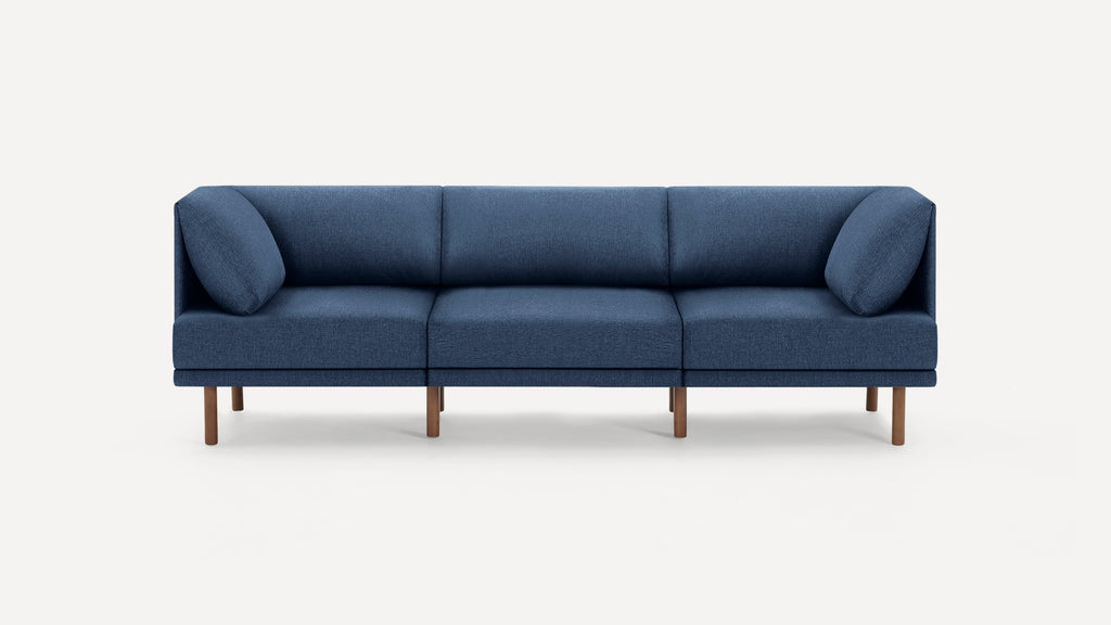 Modern three-seat sofa with blue fabric upholstery and wooden legs on a white background.