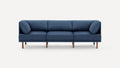 Modern three-seat sofa with blue fabric upholstery and wooden legs on a white background.