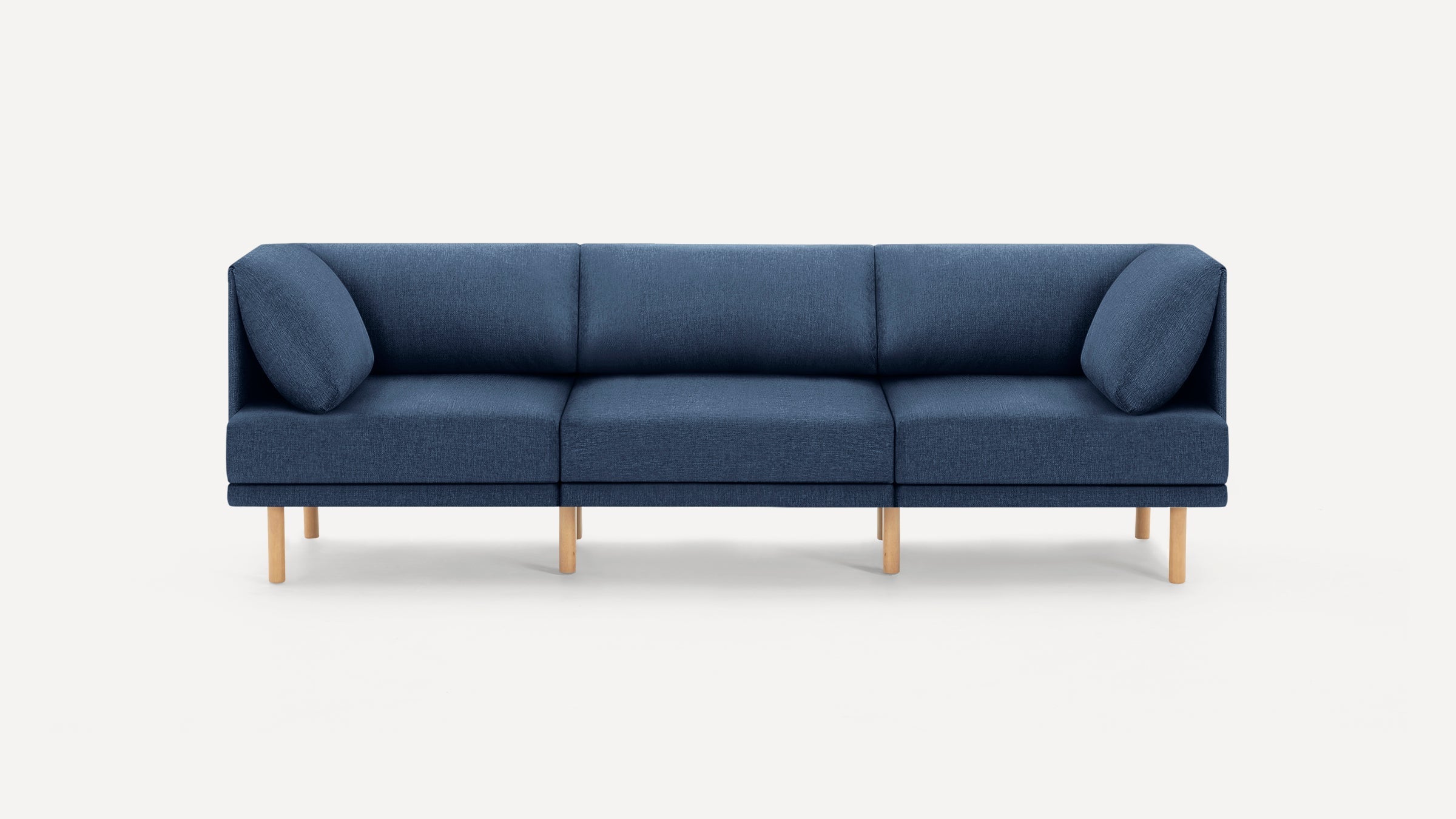 Modern three-seater sofa in deep blue fabric with wooden legs and cushioned armrests on both ends, set against white background.