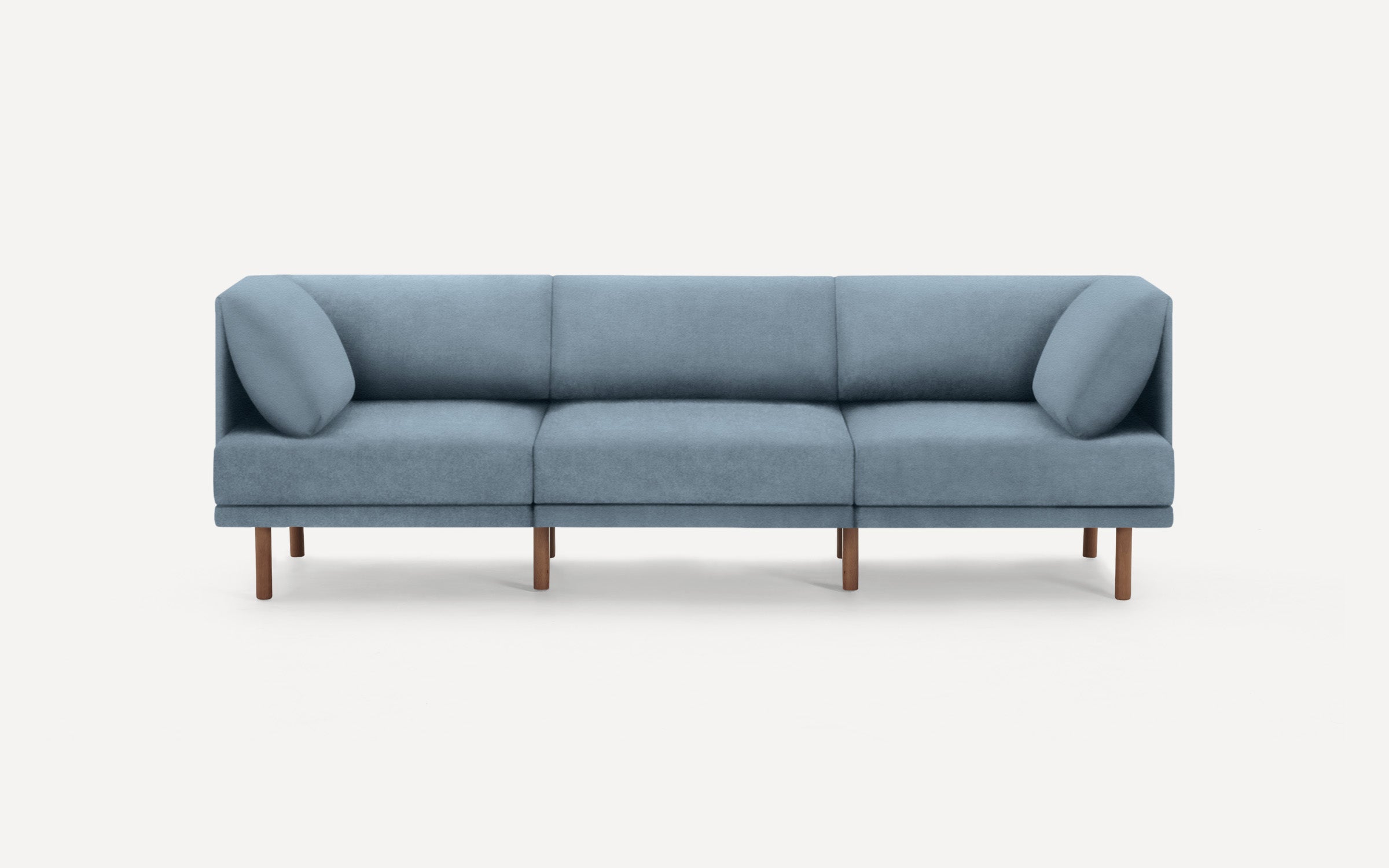 modern light blue fabric sofa with wooden legs and clean lines on a white background