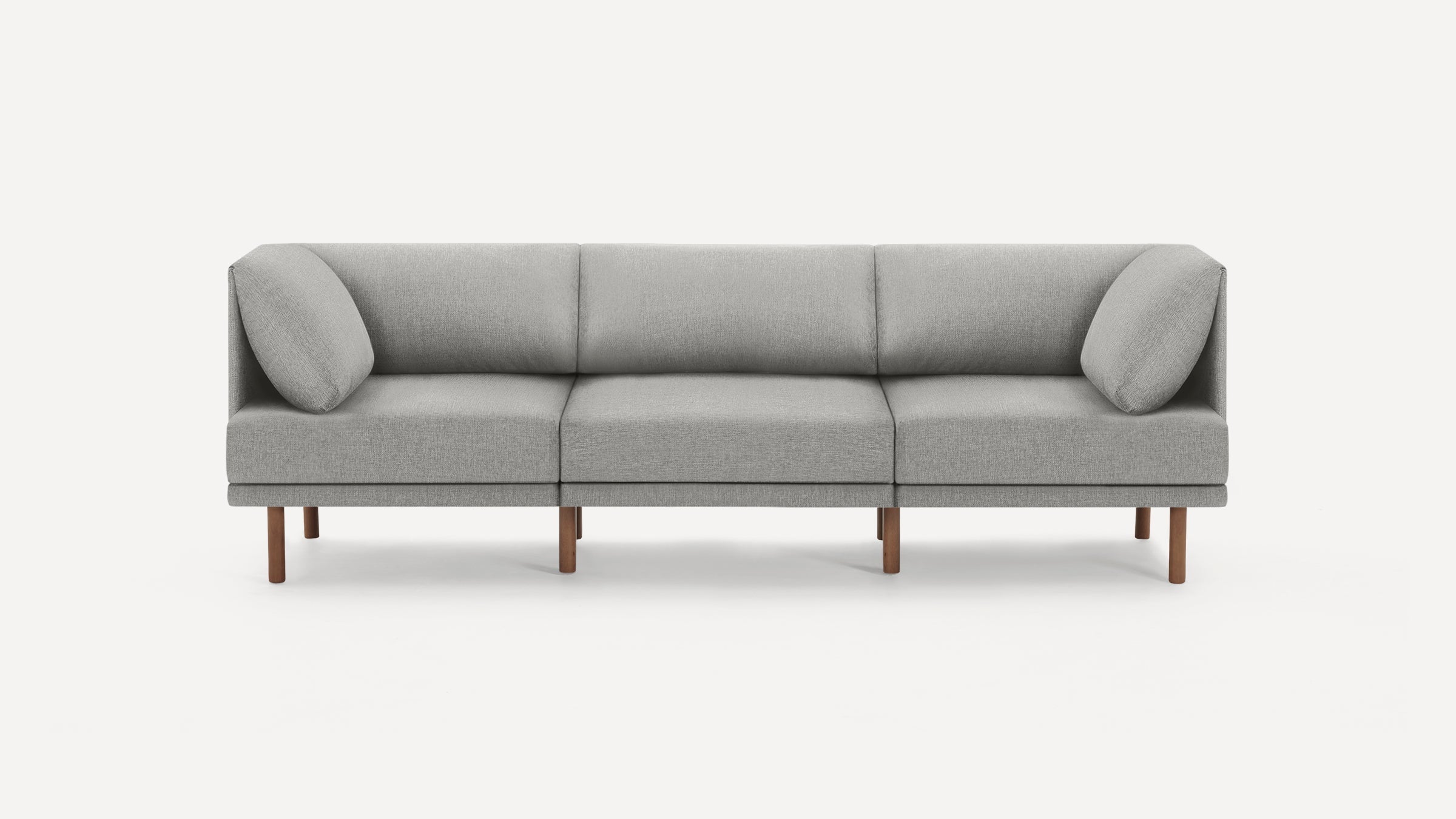 Modern three-seater sofa with light gray fabric upholstery, minimalist design, wooden legs, and cushioned armrests on both ends.