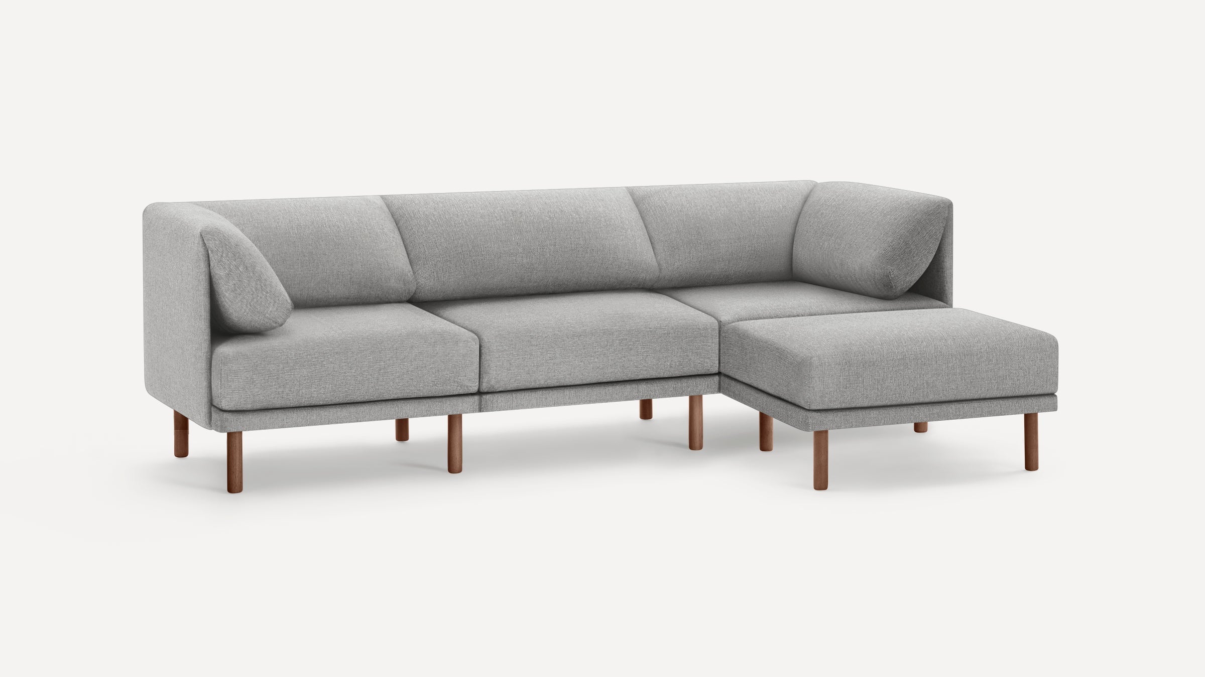 Light gray modern sectional sofa with a chaise lounge, wooden legs, and cushioned armrests against a plain background.