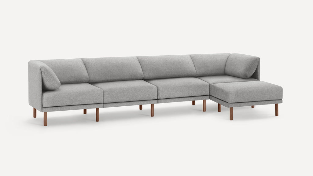 Modern light gray fabric sectional sofa with clean lines, wooden legs, and an extended chaise lounge on the right side.