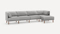 Modern light gray fabric sectional sofa with clean lines, wooden legs, and an extended chaise lounge on the right side.
