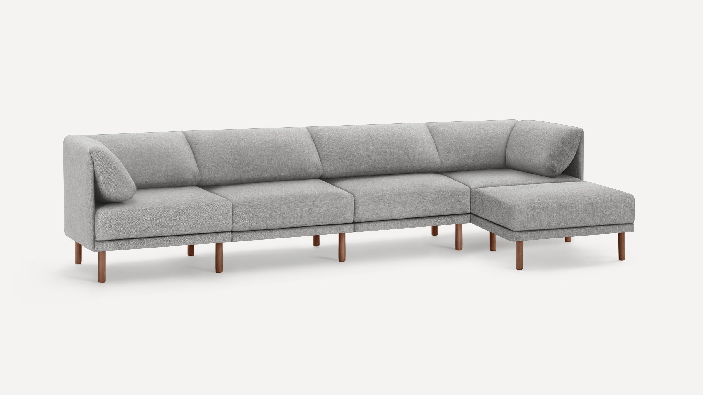 Modern light gray fabric sectional sofa with clean lines, wooden legs, and an extended chaise lounge on the right side.