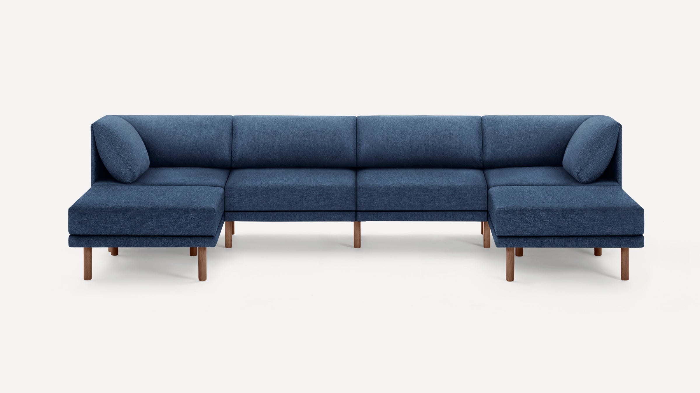 Modern navy blue fabric sectional sofa with wooden legs, low backrests, and two matching round cushions.