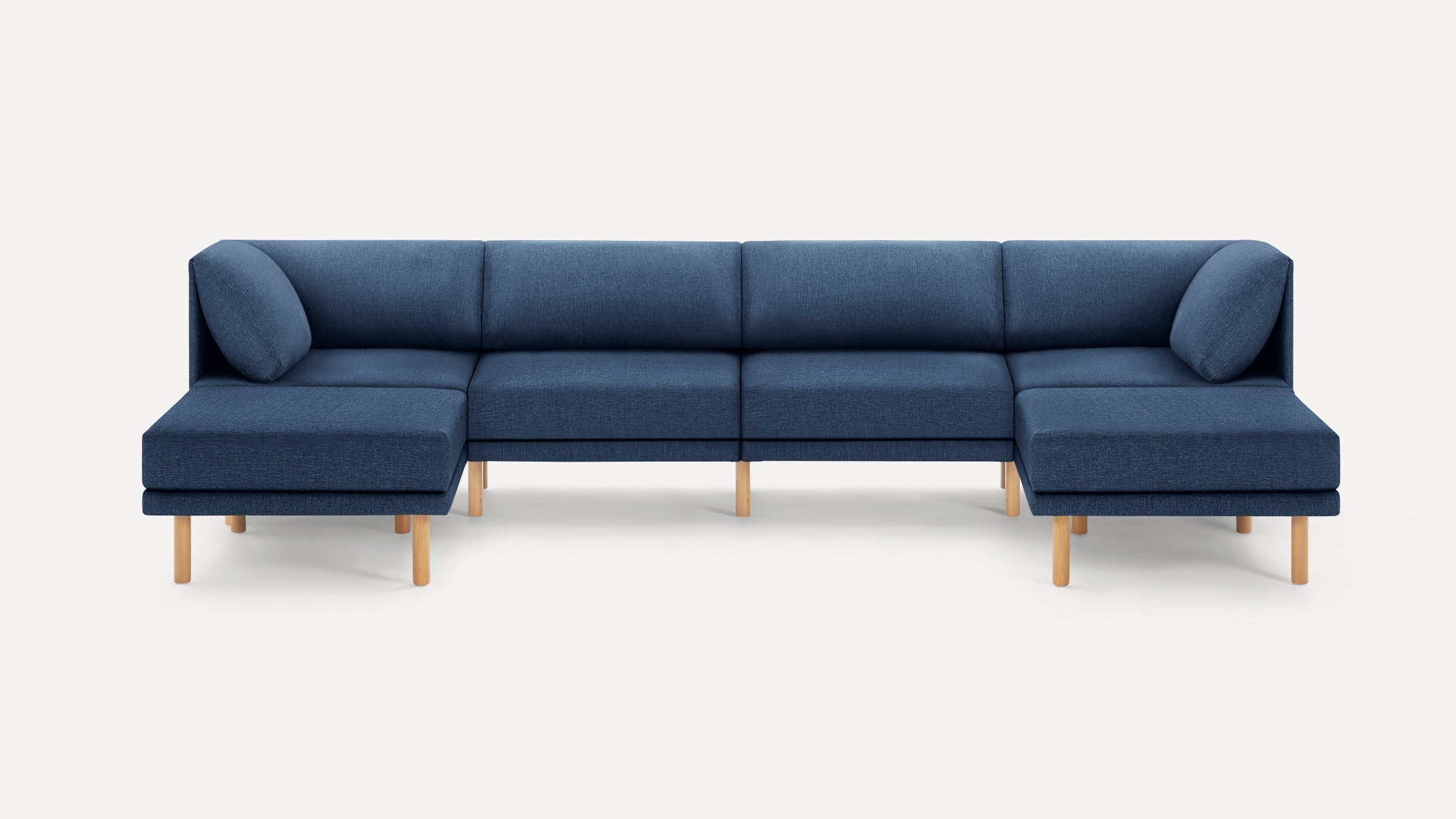 Modern navy blue L-shaped sectional sofa with wooden legs and cushioned backrest pillows on both ends.